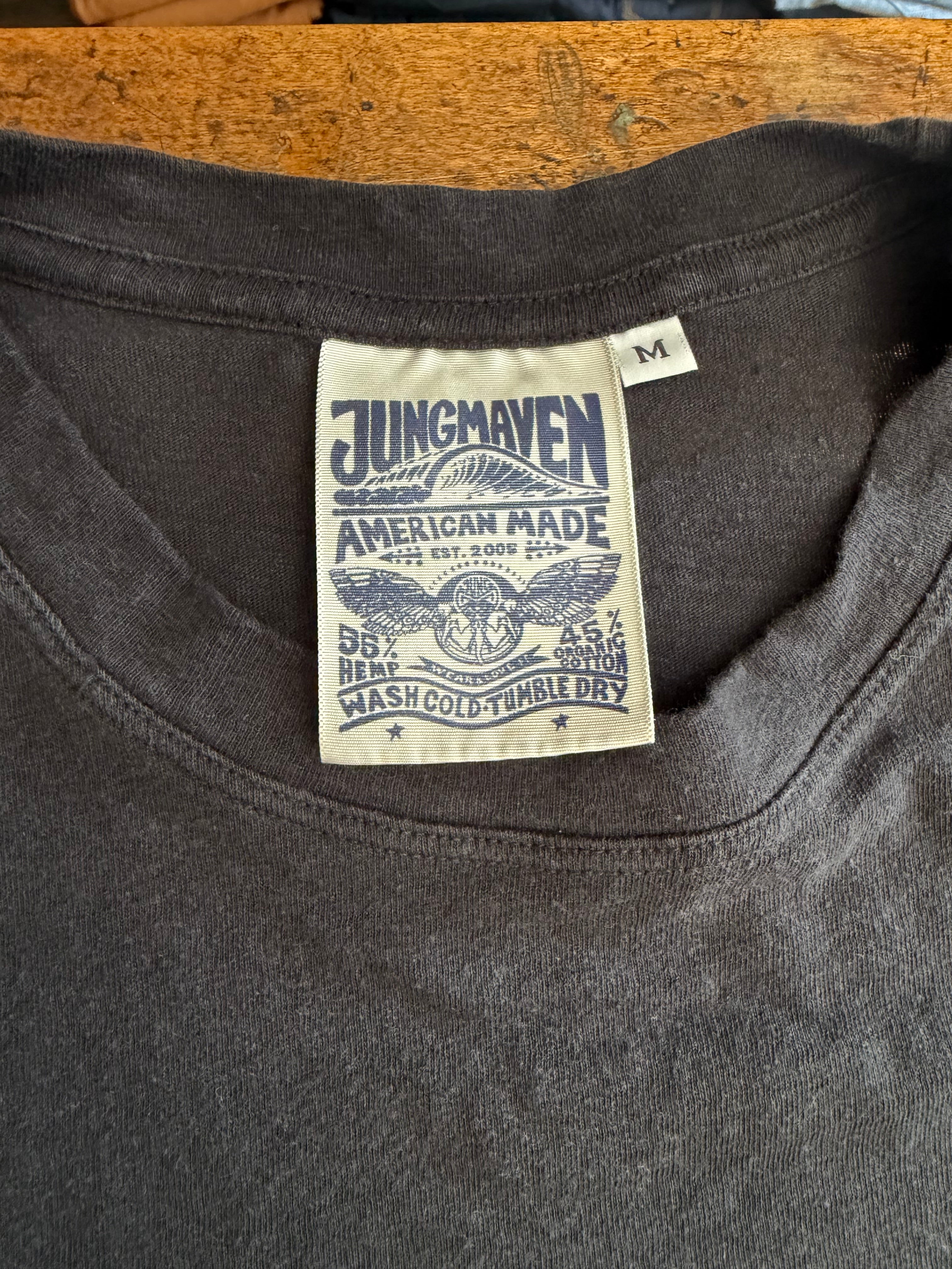 Close-up of dark gray t-shirt collar showing Jungmaven tag with American Made details and size M.