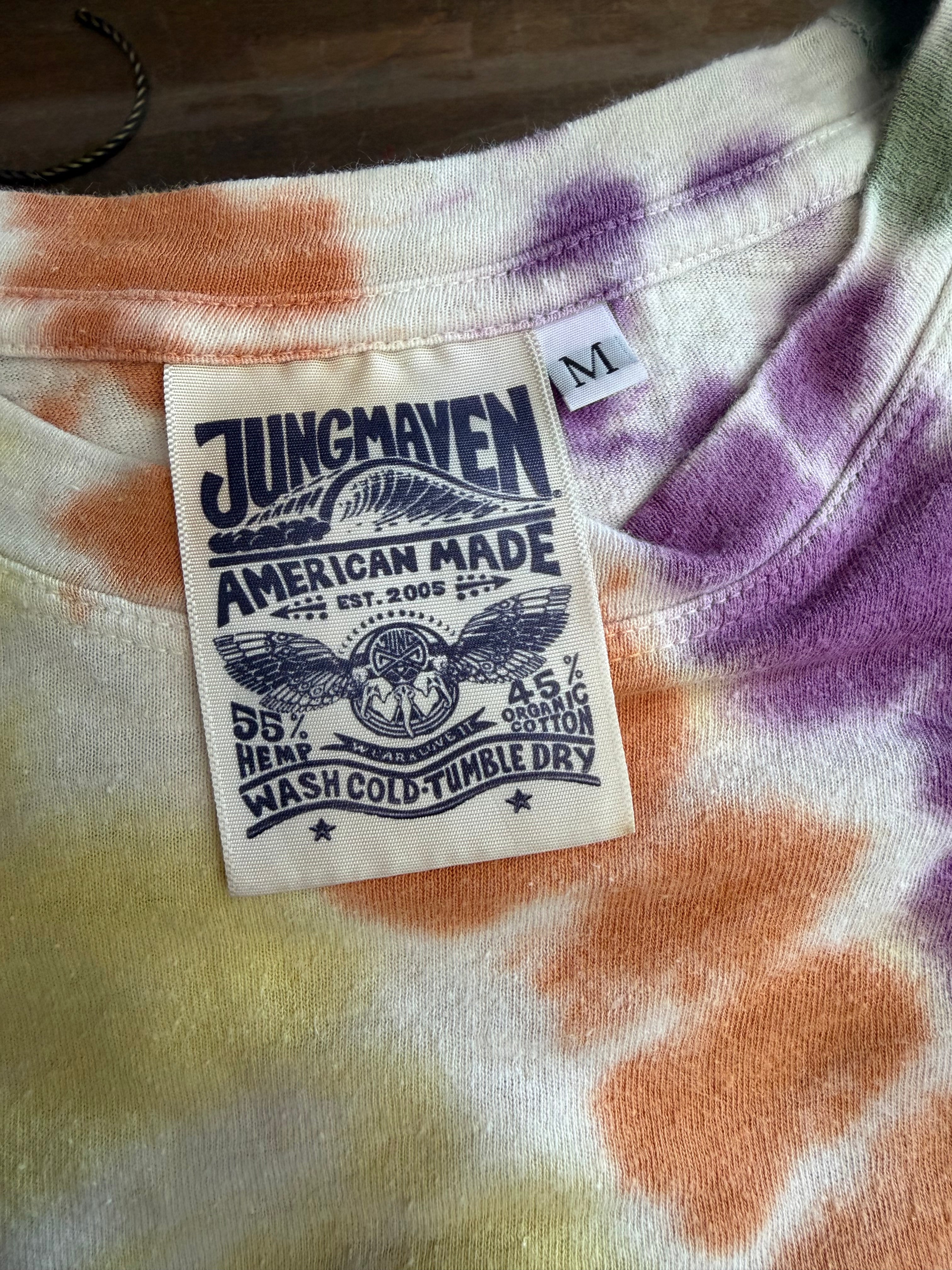 Close-up of tie-dye tee's back neck tag: Jungmaven American Made, 55% hemp, 45% organic cotton, size M