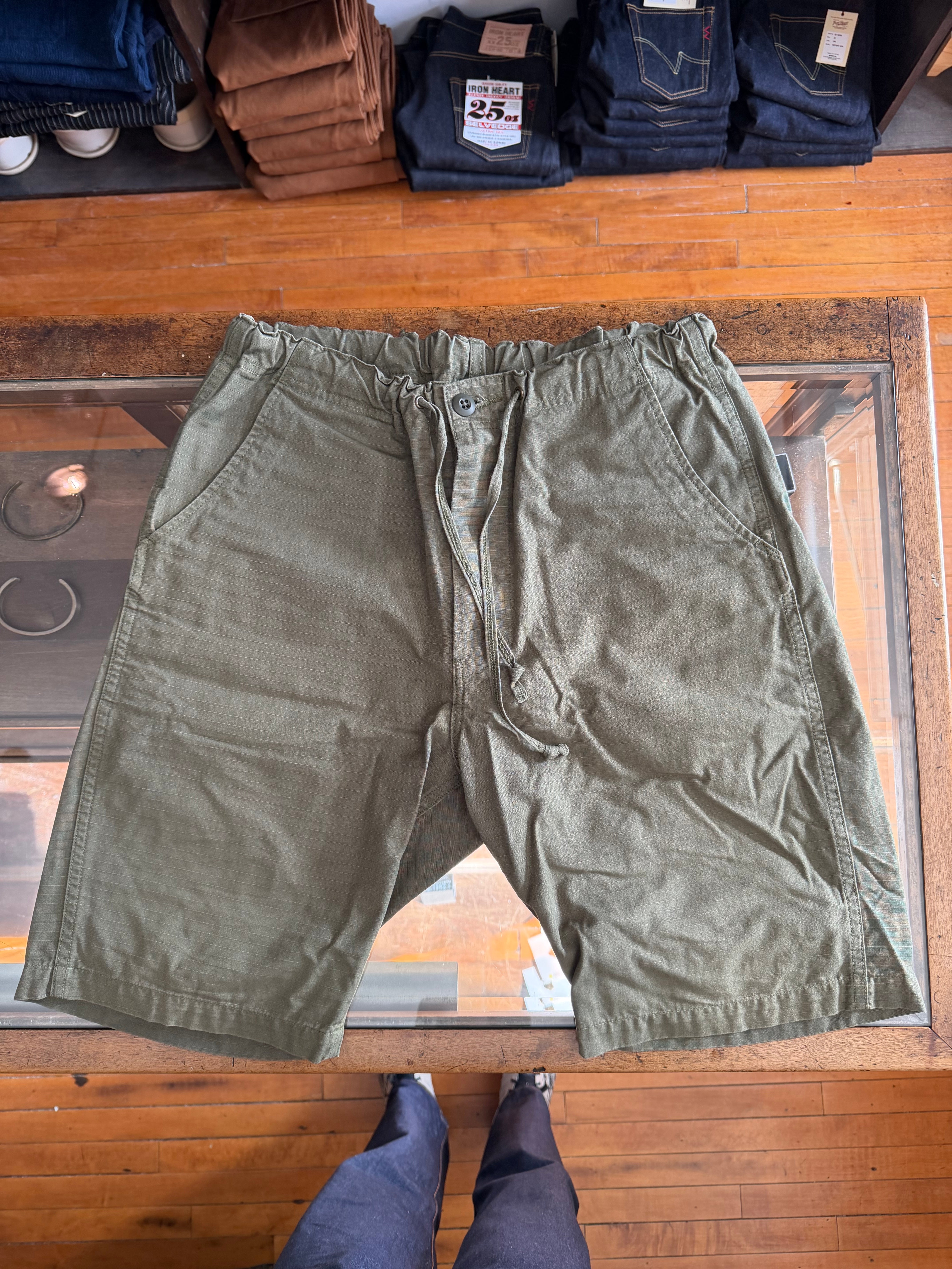 Flat lay front view of olive green drawstring casual shorts with button detail, Dant store