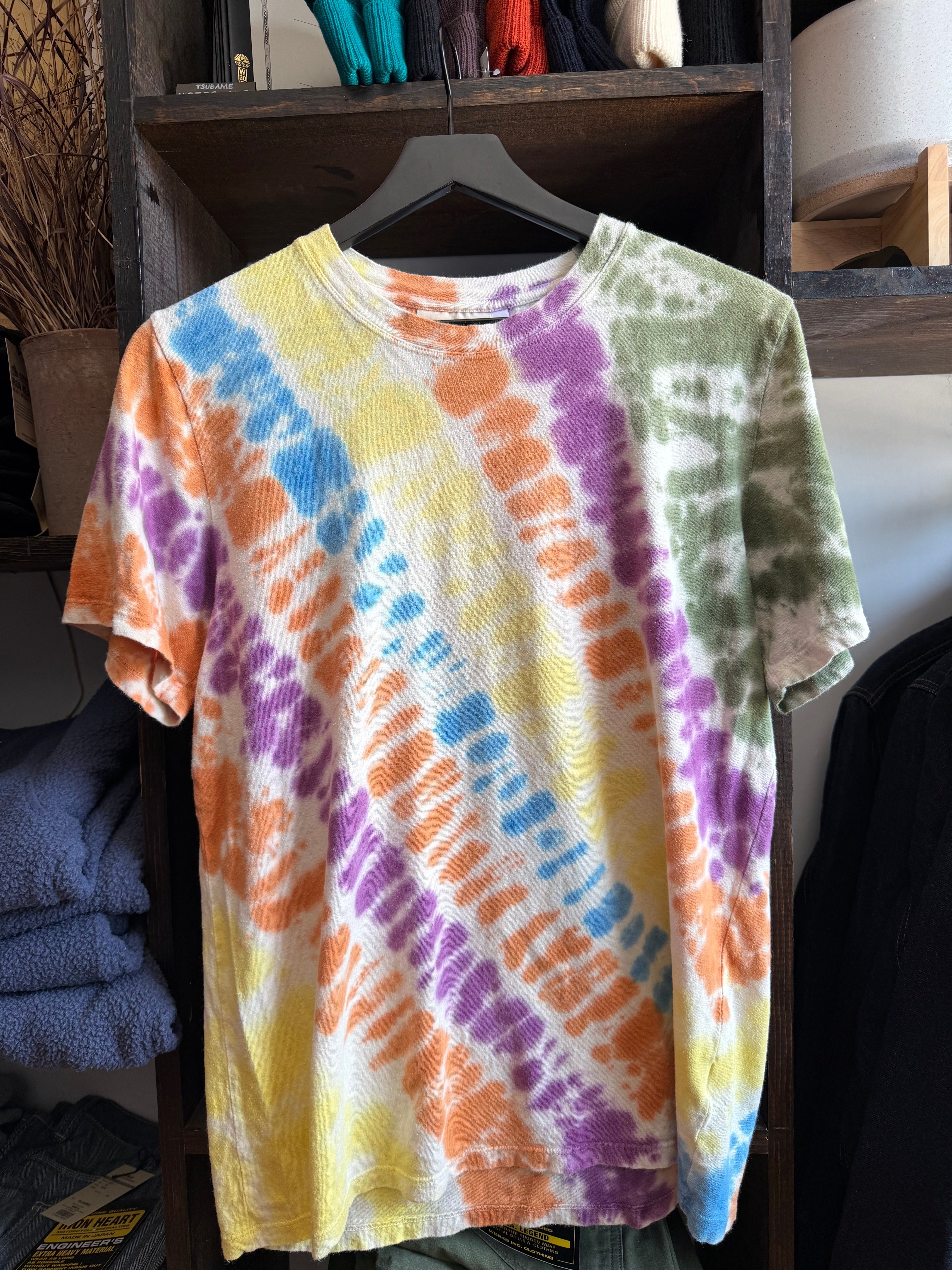 Front view of men's colorful tie-dye short sleeve t-shirt on hanger, featuring orange, purple, blue, yellow, green patterns, crew neck, relaxed fit