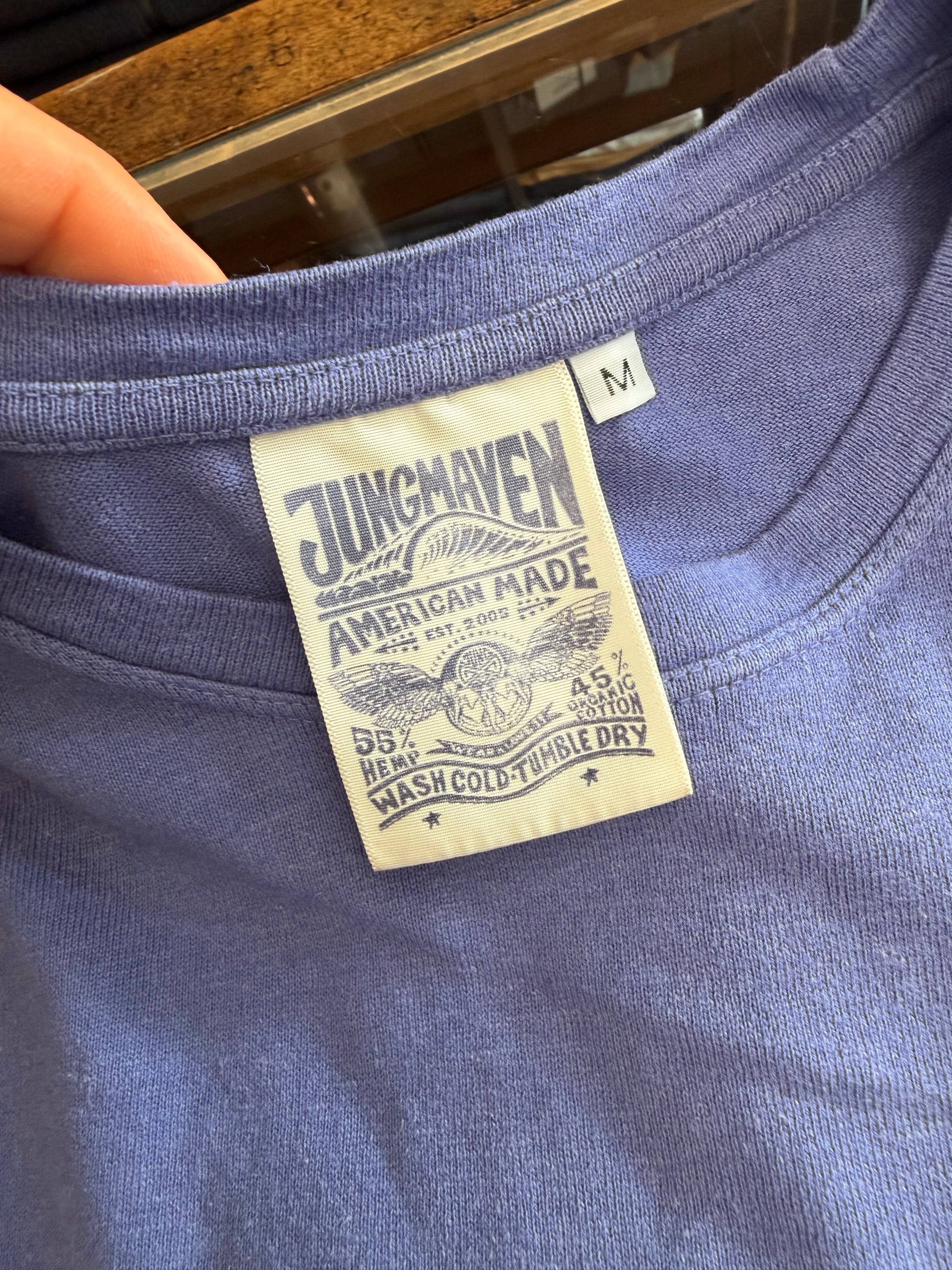 Close-up of purple t-shirt tag showing Jungmaven brand, 55% hemp 45% organic cotton, American made, size M