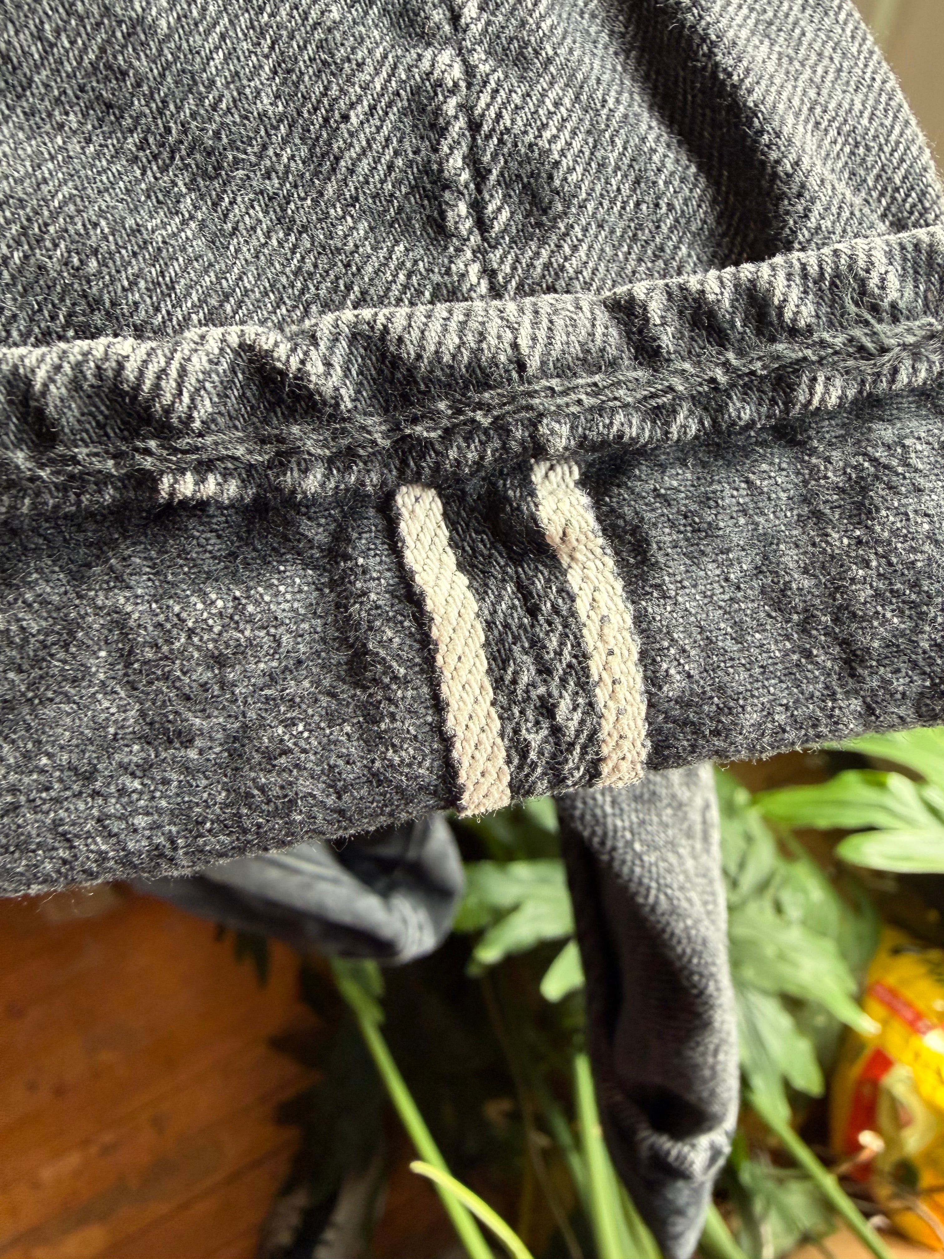 Close-up of selvedge denim cuff hem, showing fabric texture and stitching, front view.