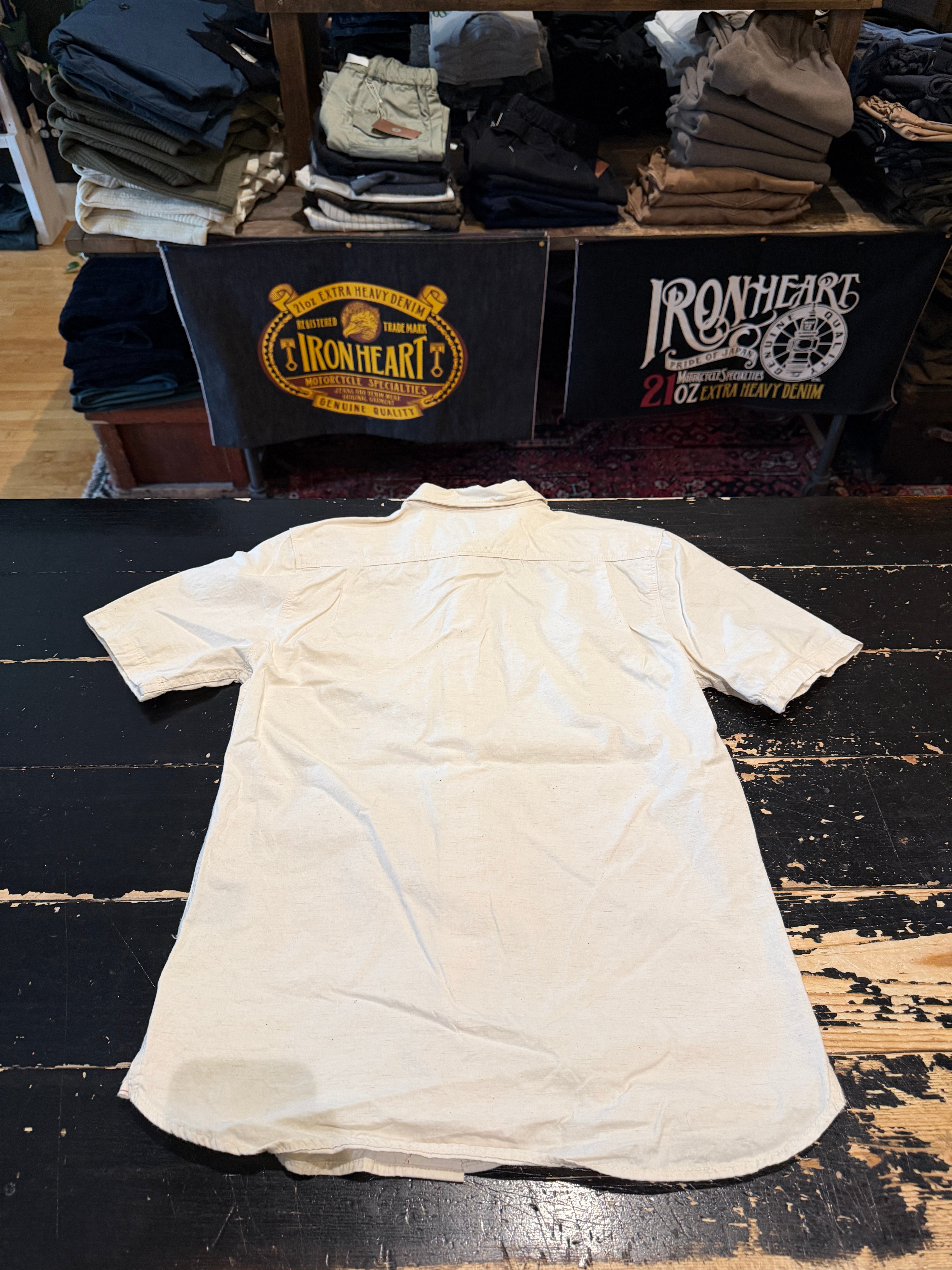 Flat lay of short sleeve button-up shirt, back side, showing collar and hem detail.