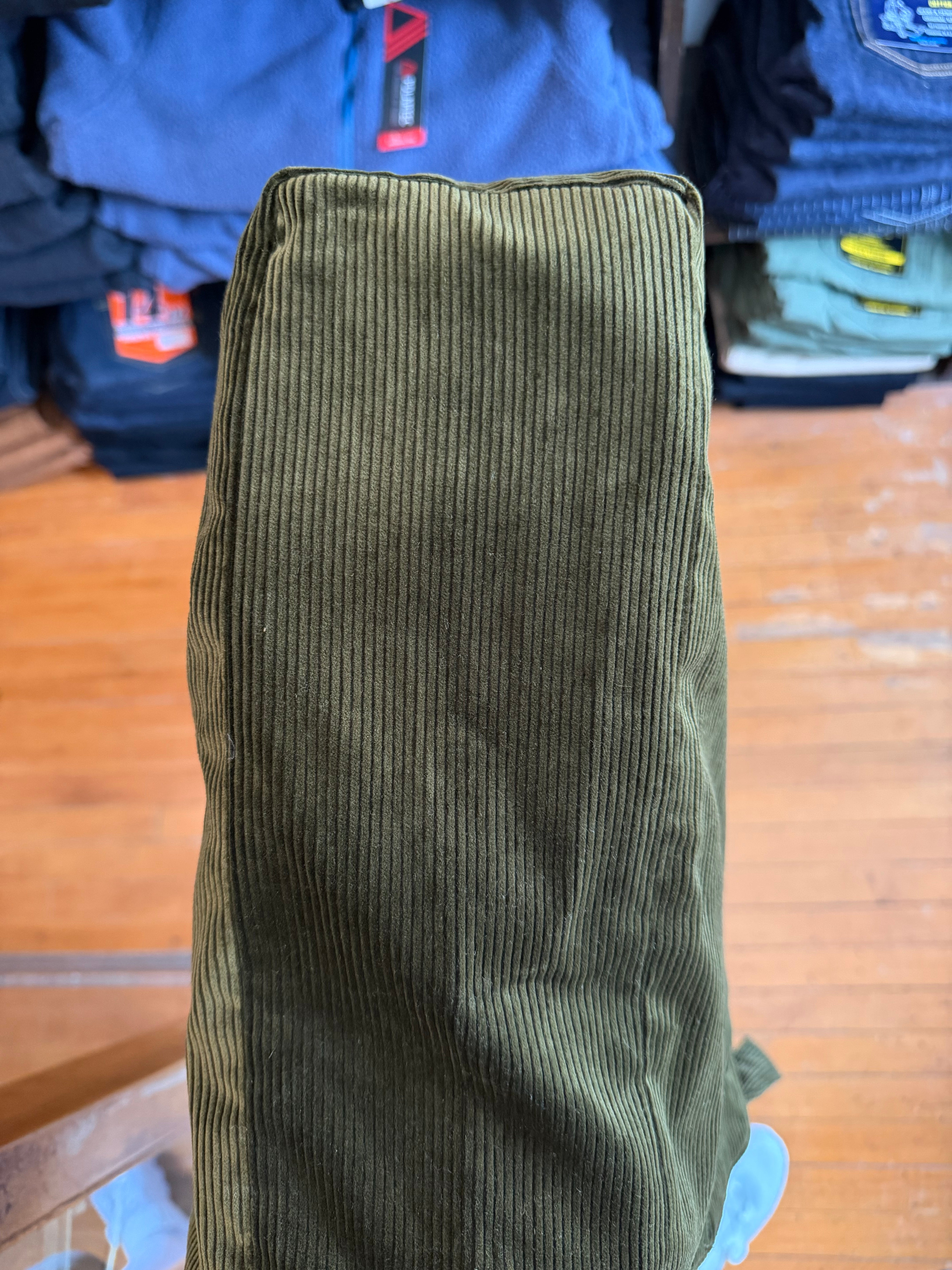Close-up of olive corduroy pants leg, showcasing texture and hem, worn by male model