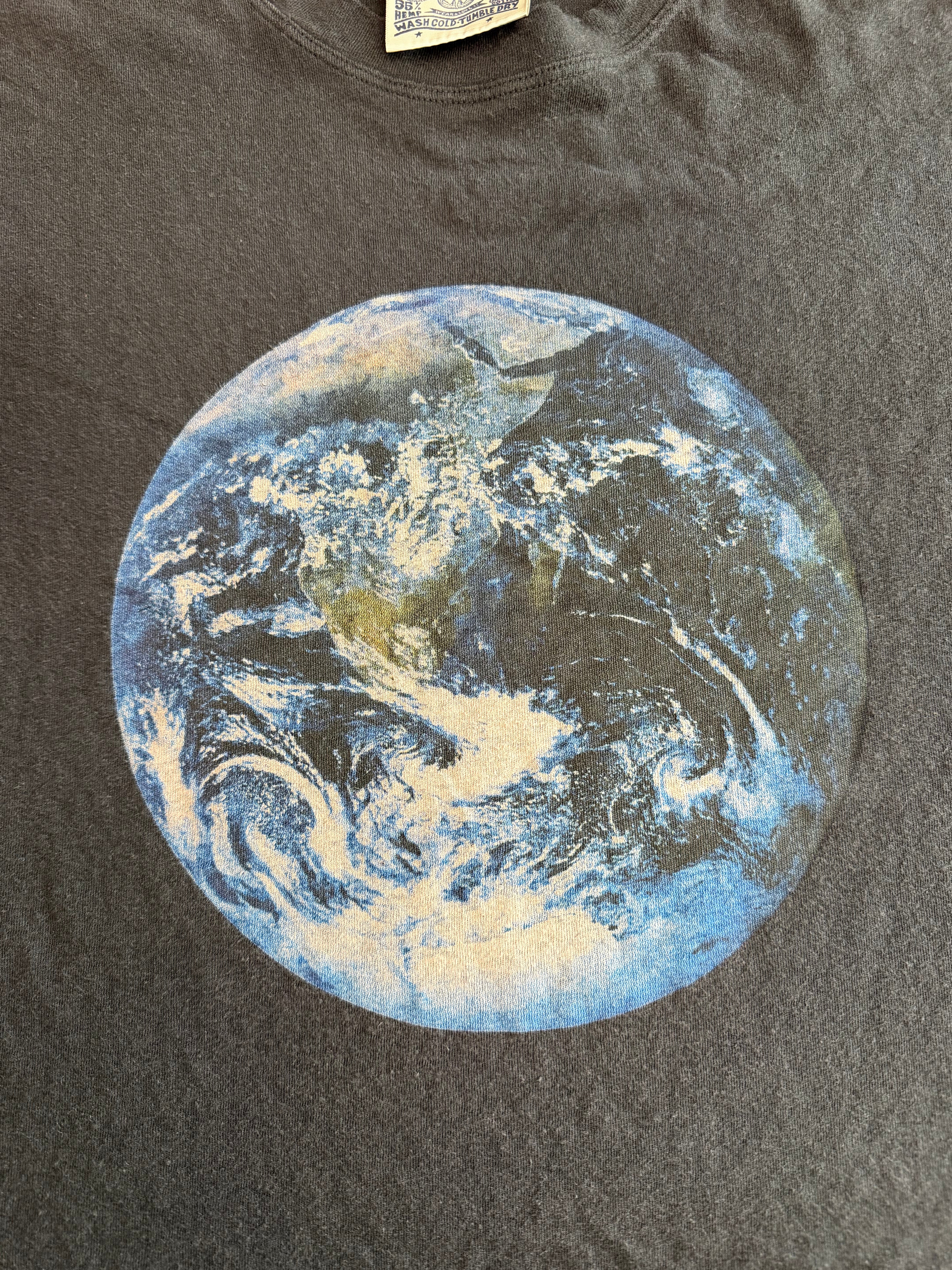 Front close-up of dark gray T-shirt with Earth graphic, tag visible at neckline