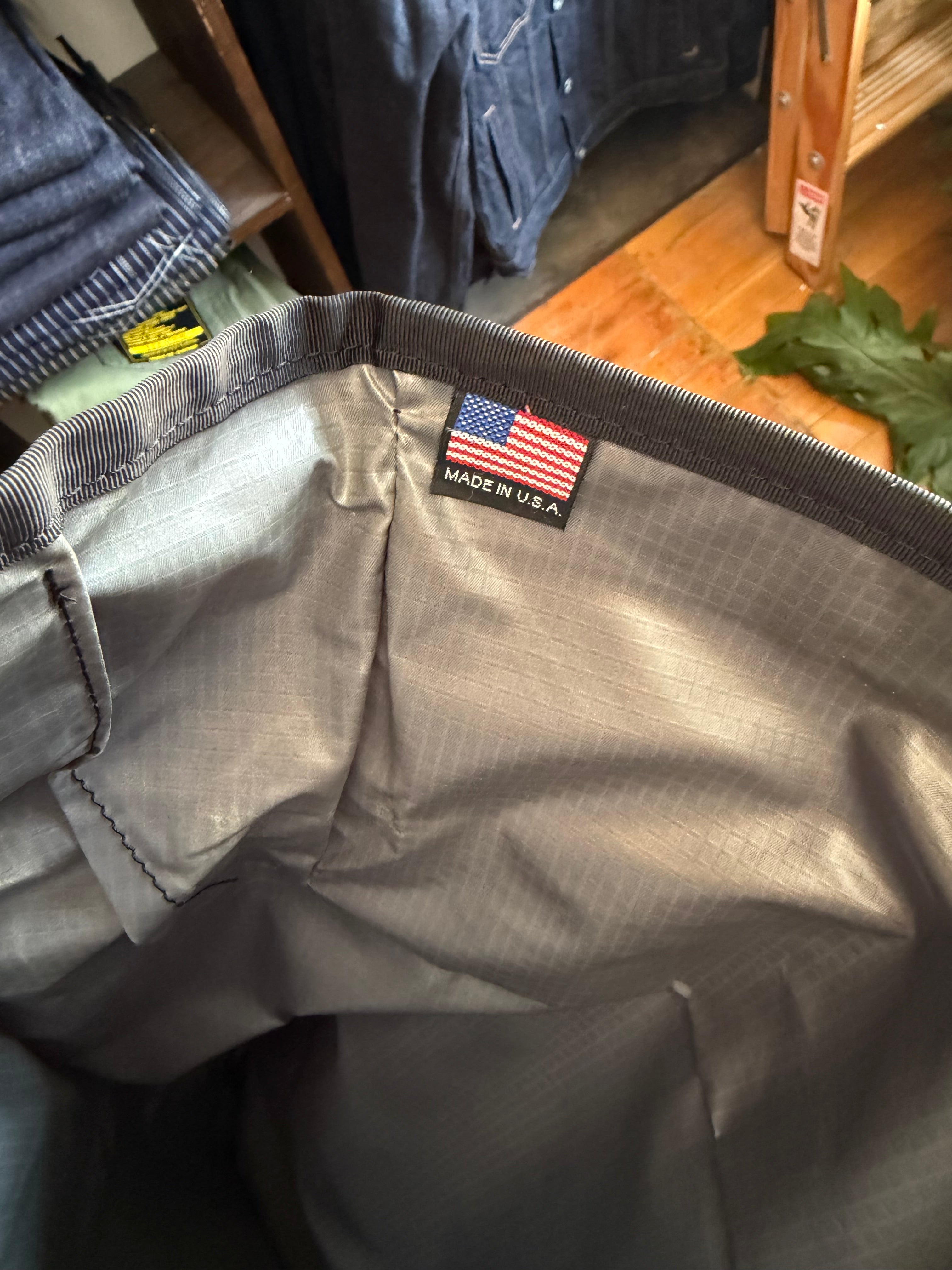 Close-up of gray pants interior, front view, showing striped waistband, USA flag tag, and fabric texture