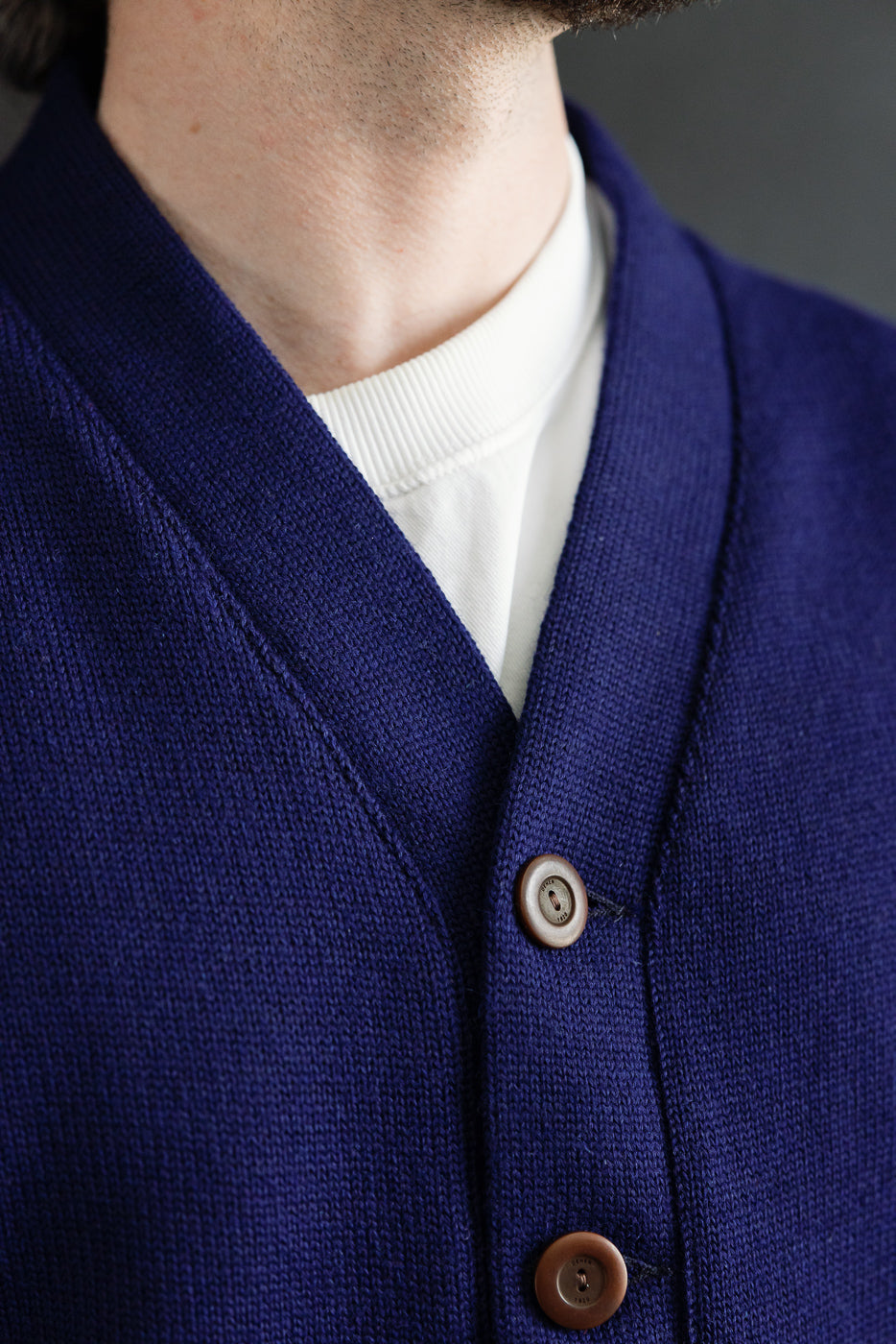 Close-up of men's classic purple cardigan front, showing V-neck collar and buttons, modeled by male, 5'9