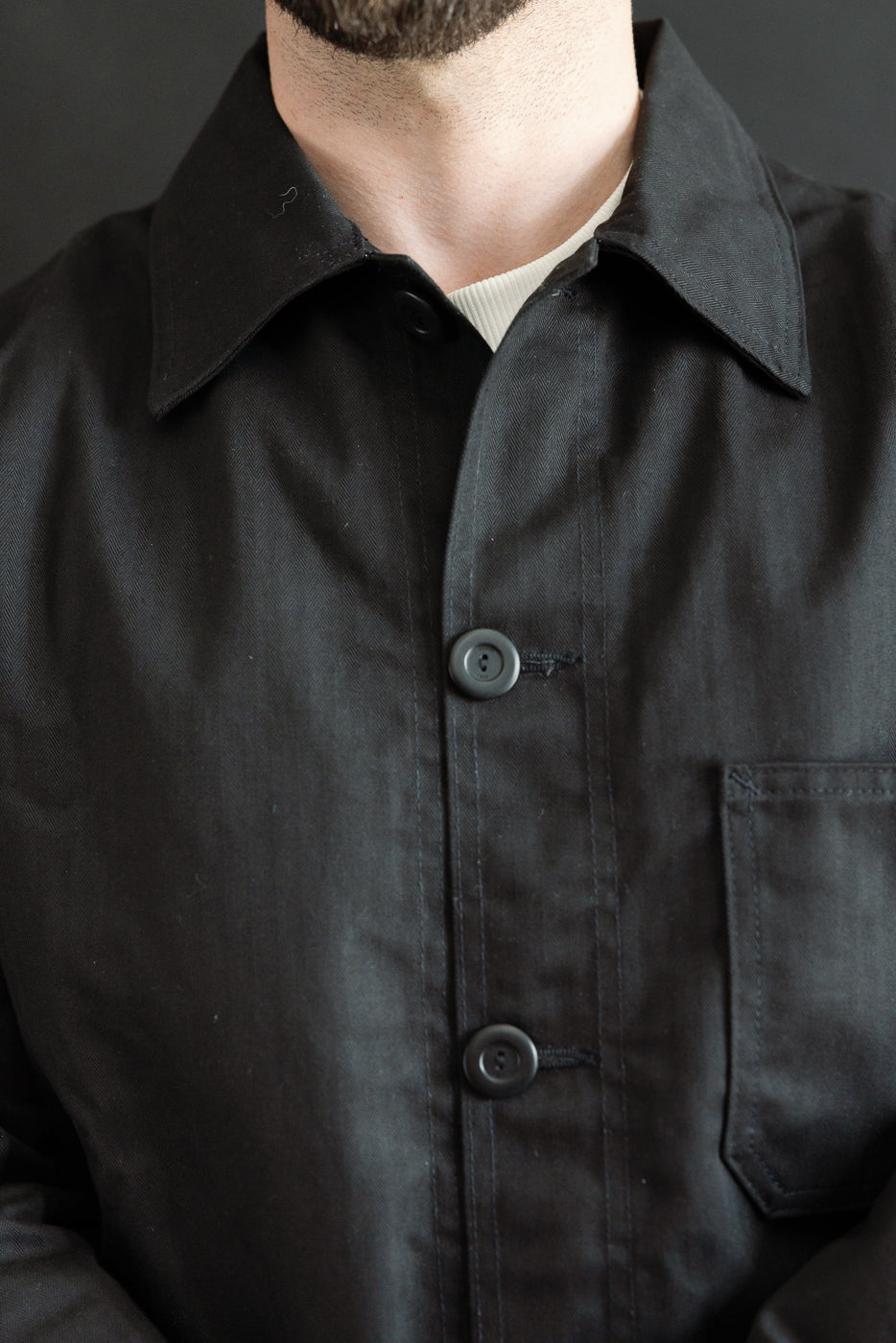 Close-up front view of black woven chore coat on male model 5'9