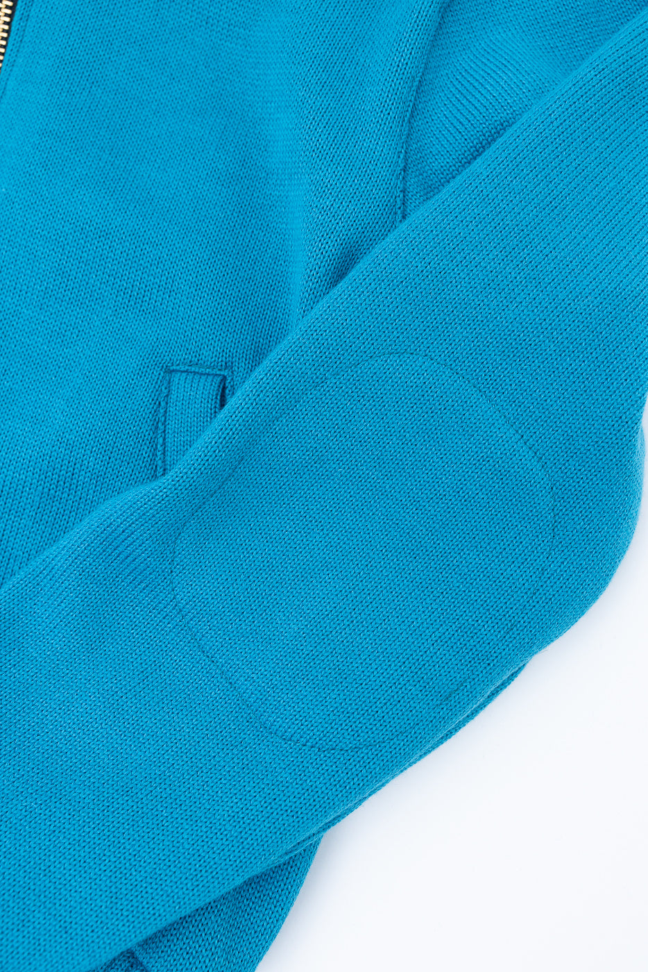Close-up of aqua full-zip moto hoodie sleeve, showing elbow patch detail and fabric texture.