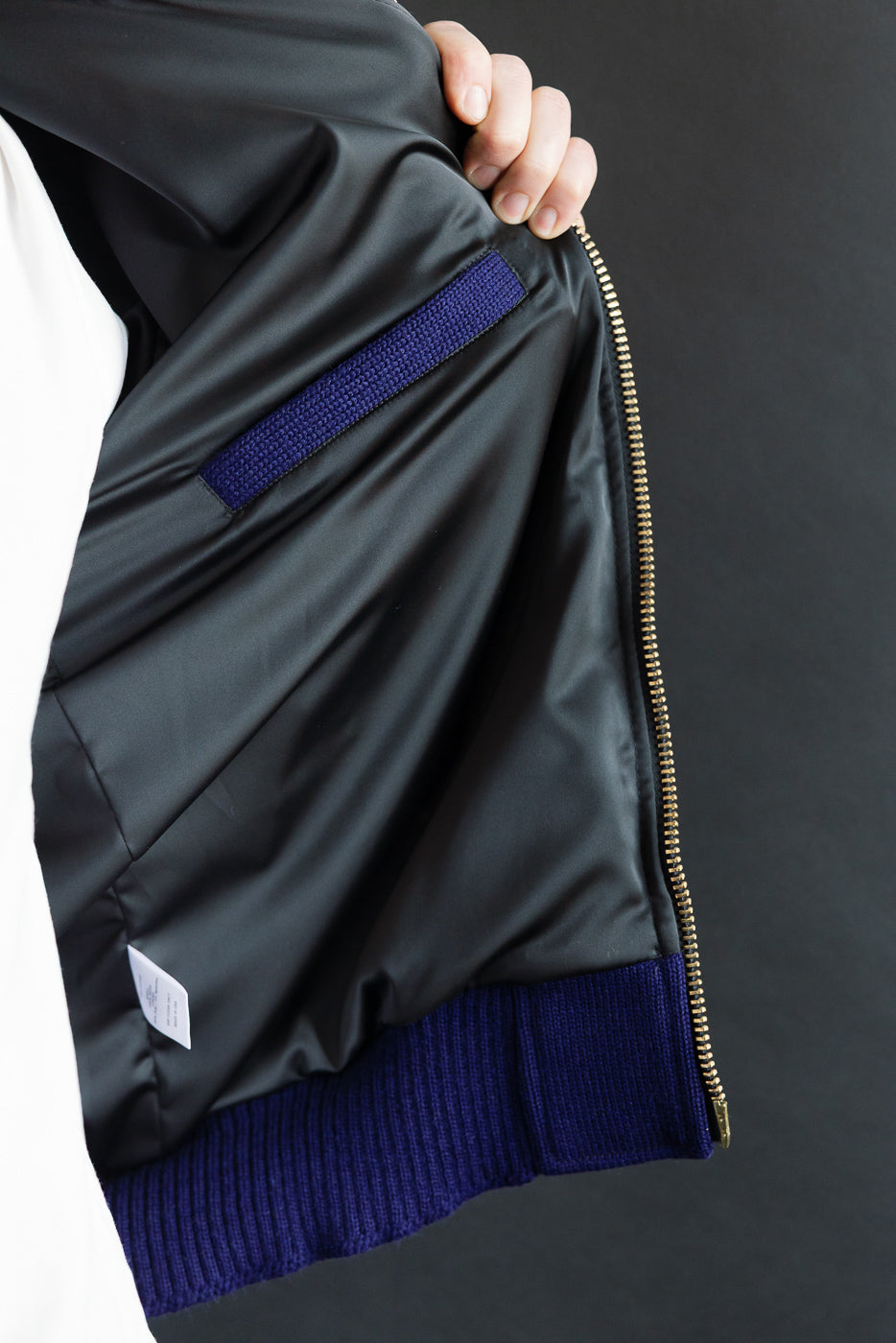 Close-up of men's moto hoodie inside lining, showing interior pocket and ribbed purple hem.