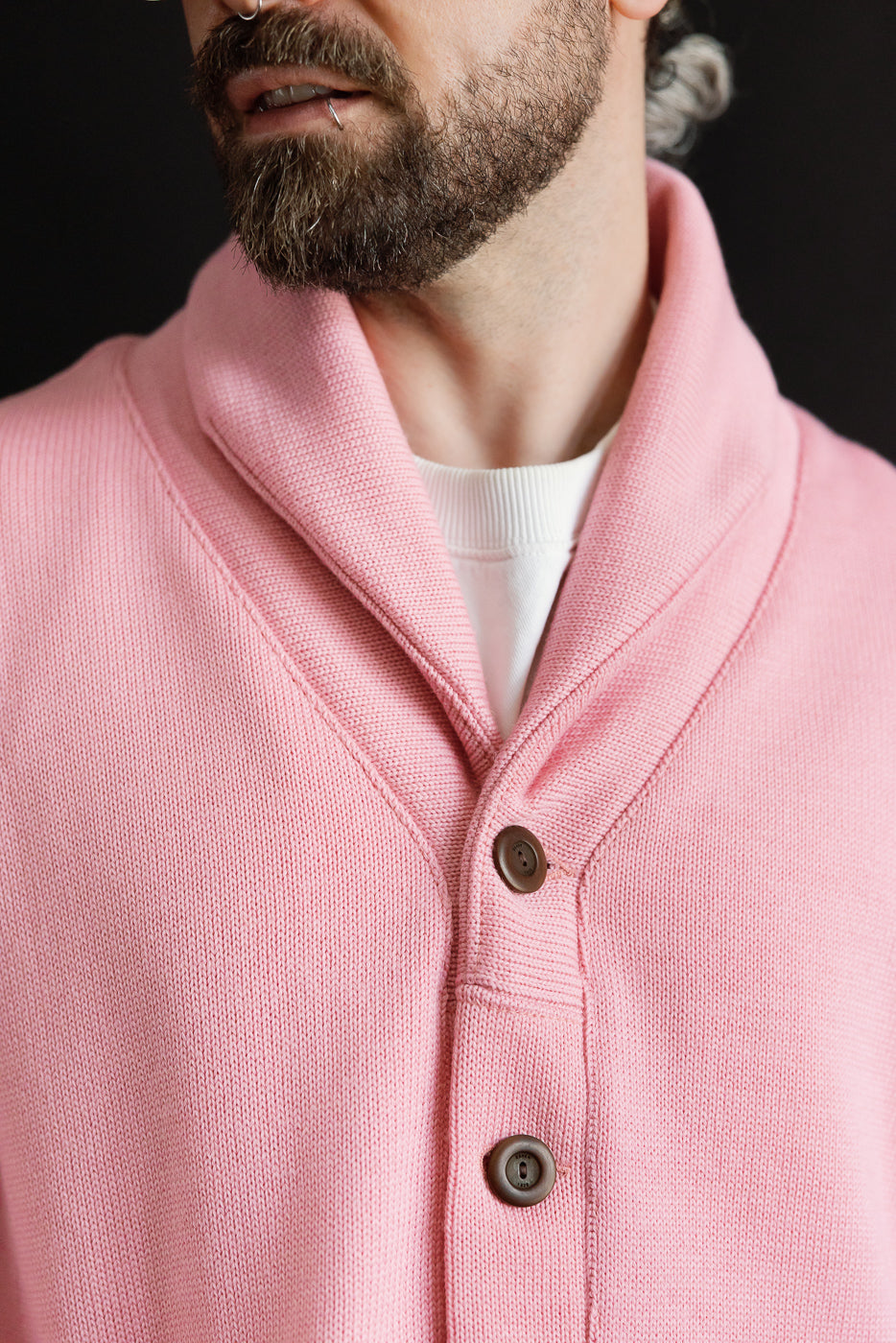 Close-up of men's shawl collar sweater coat in bubblegum pink, front buttons visible, male model 5'9