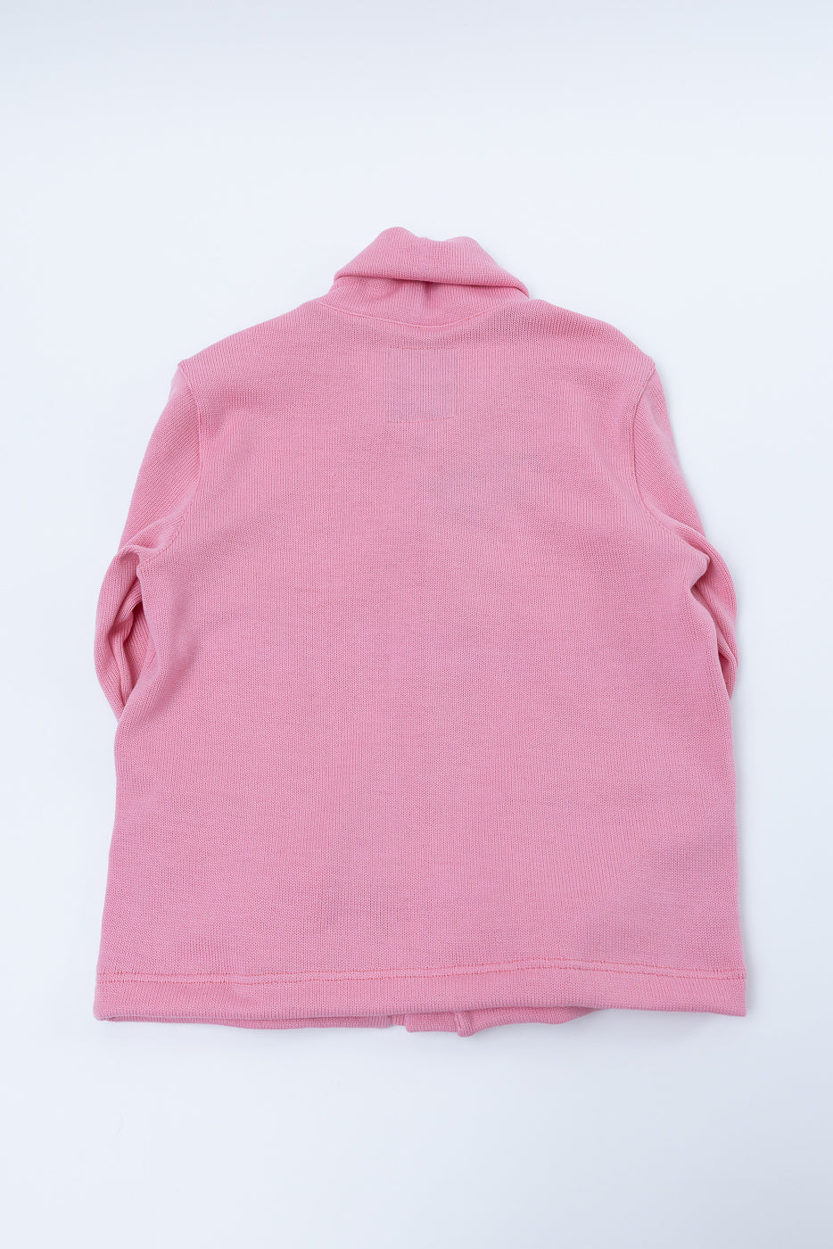 Flat lay, back view of bubblegum pink shawl sweater coat showing collar and hem details.