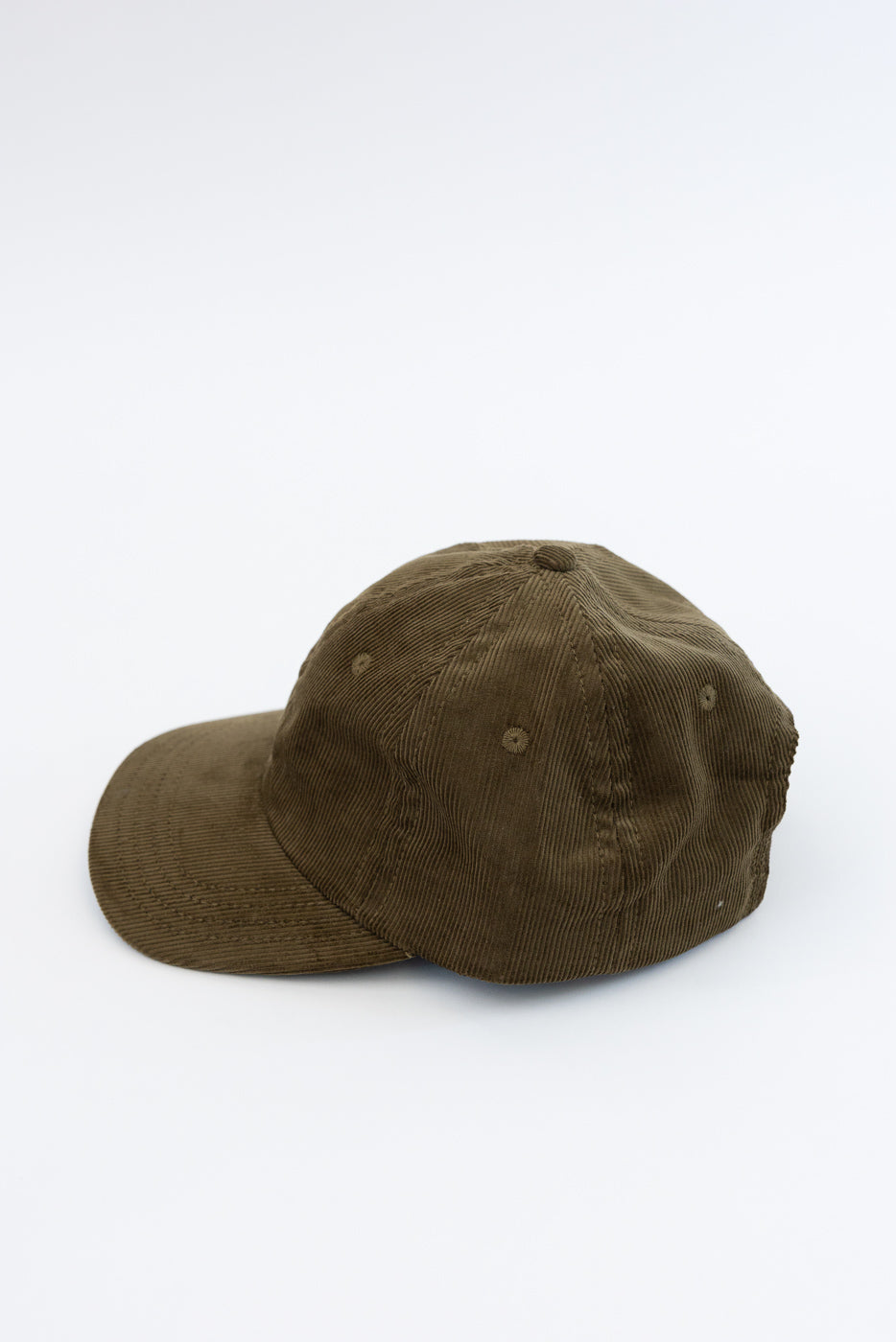 Corduroy Baseball Hat - Olive: A six-panel baseball cap made of soft, thin-wale brown corduroy, featuring a pre-curved brim and adjustable leather strap with brass buckle, embodying classic and crafted utility.