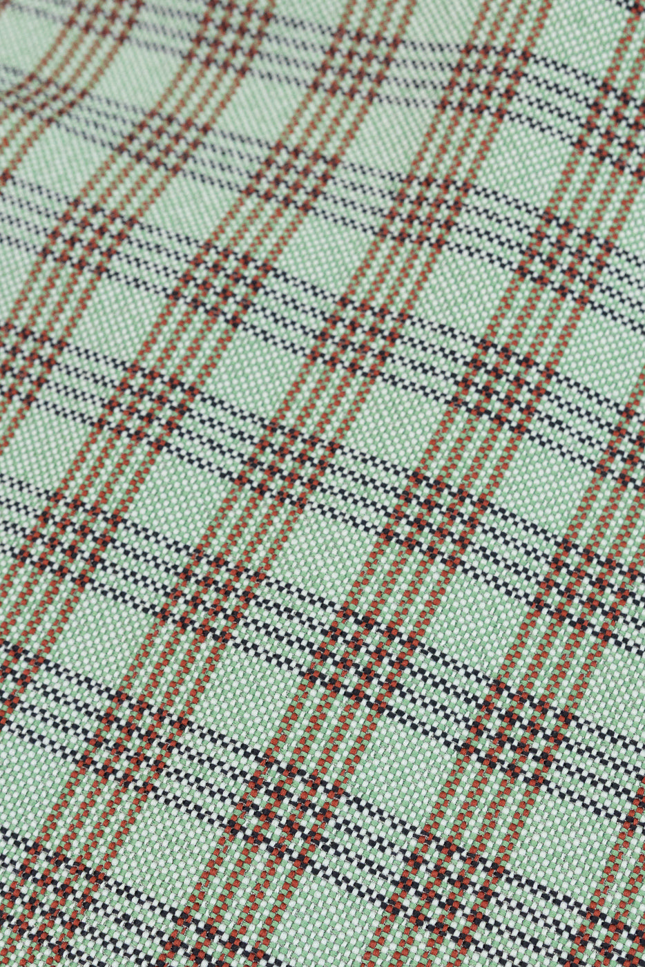 Close-up detail of green plaid lounge shirt fabric texture, focusing on material pattern.