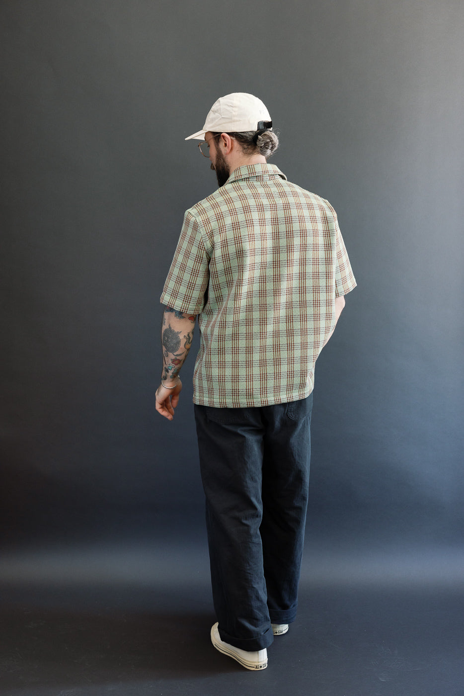 Full body back view of male model 5'9 165lbs athletic build wearing green plaid short sleeve shirt