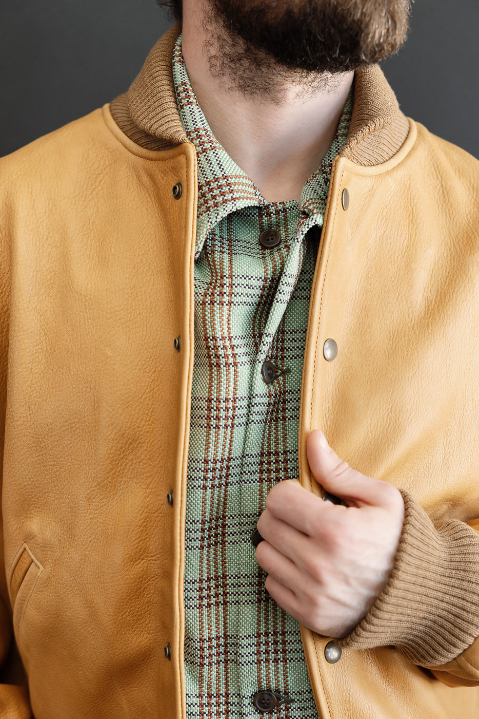 Close-up front view of men's leather jacket with ribbed collar and cuff, on male model 5'9
