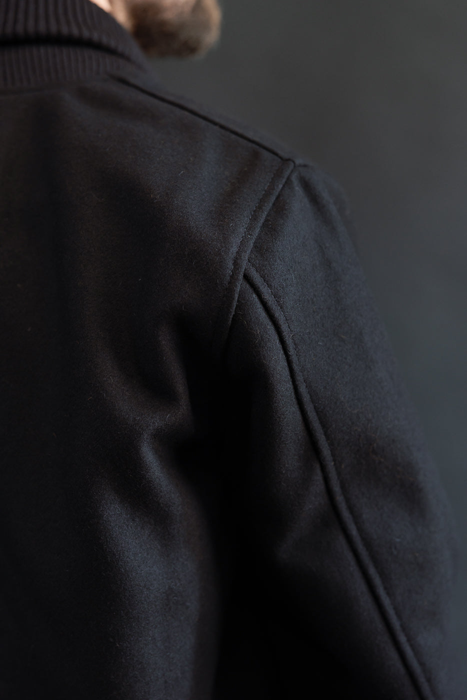close up of back shoulder seem of black wool jacket