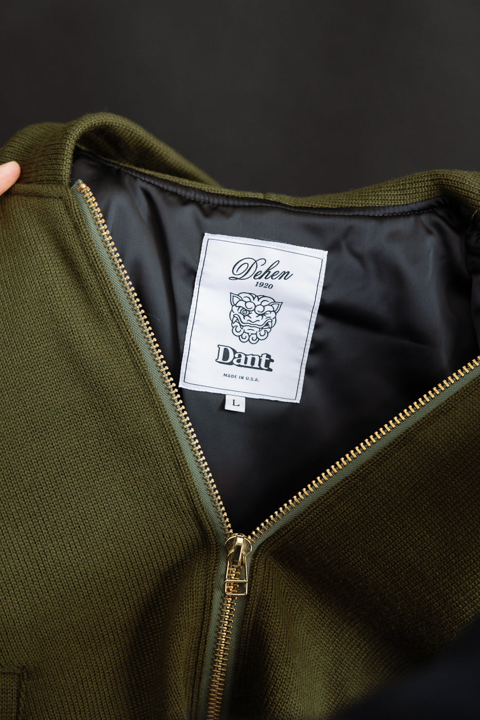 close up of white woven label featuring black dehen x dant print