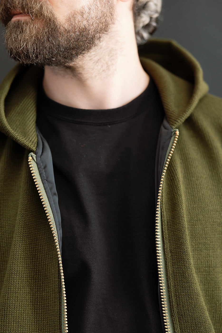 close up of hood and brass zipper, open against a black t shirt