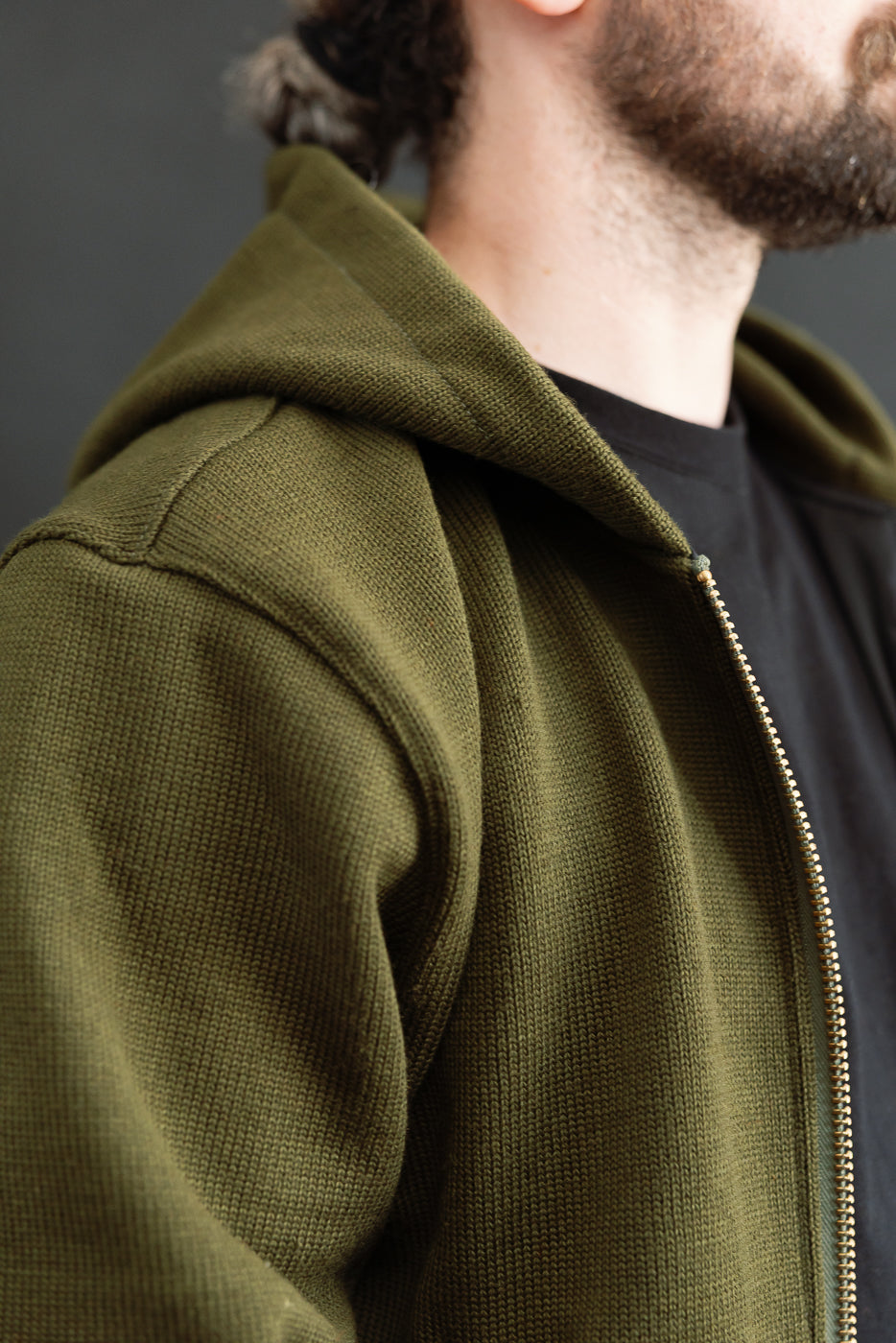 close up of knitted olive green sweater shoulder seam, front