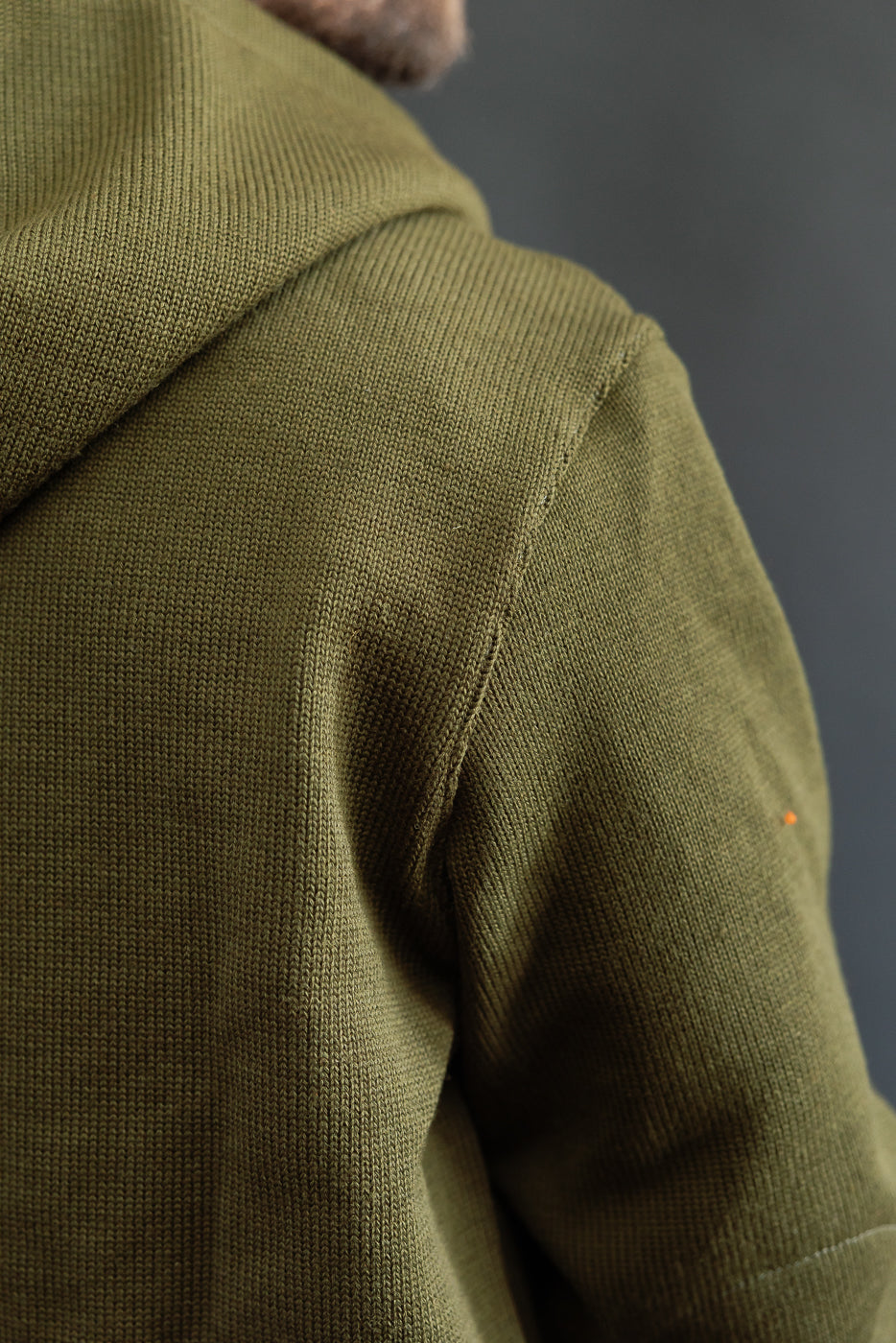 close up of knitted olive green sweater shoulder seam, back