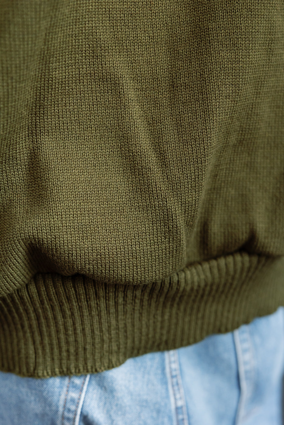 close up of olive green knitted hoodie hem