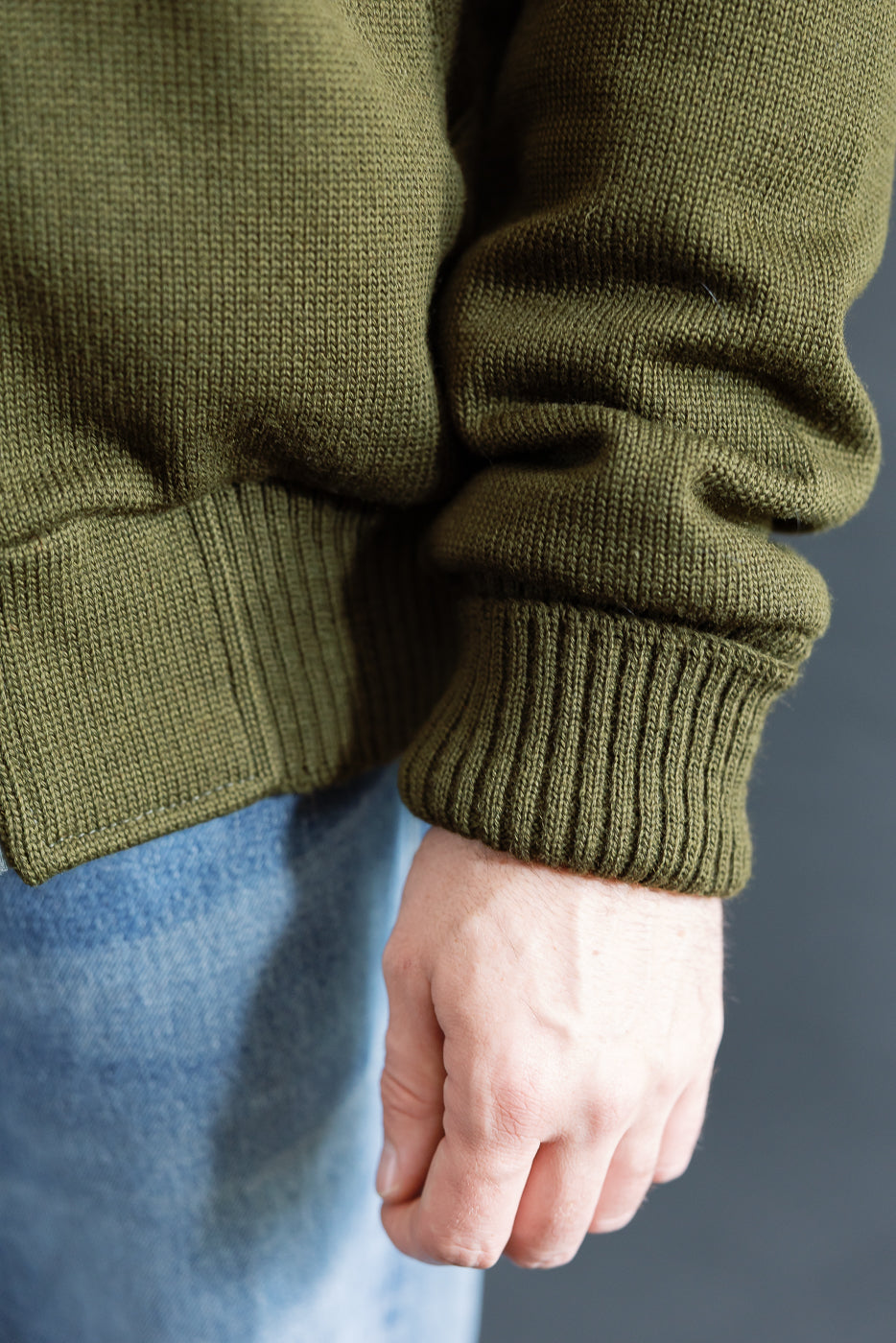 close up of olive green knitted hoodie  ribbed sleeve