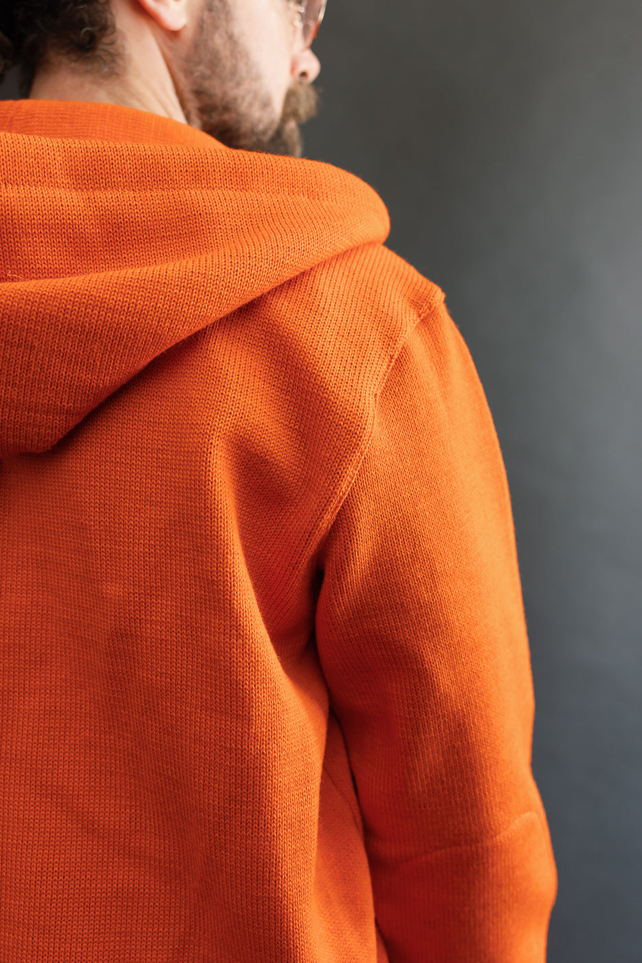 close up of orange knitted hoodie, back shoulder