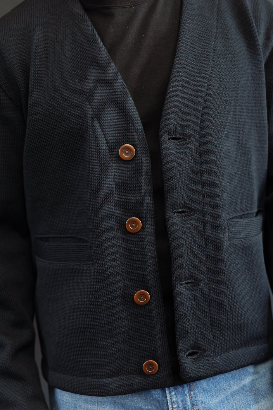close up of open placket with large corozo buttons on black cardigan