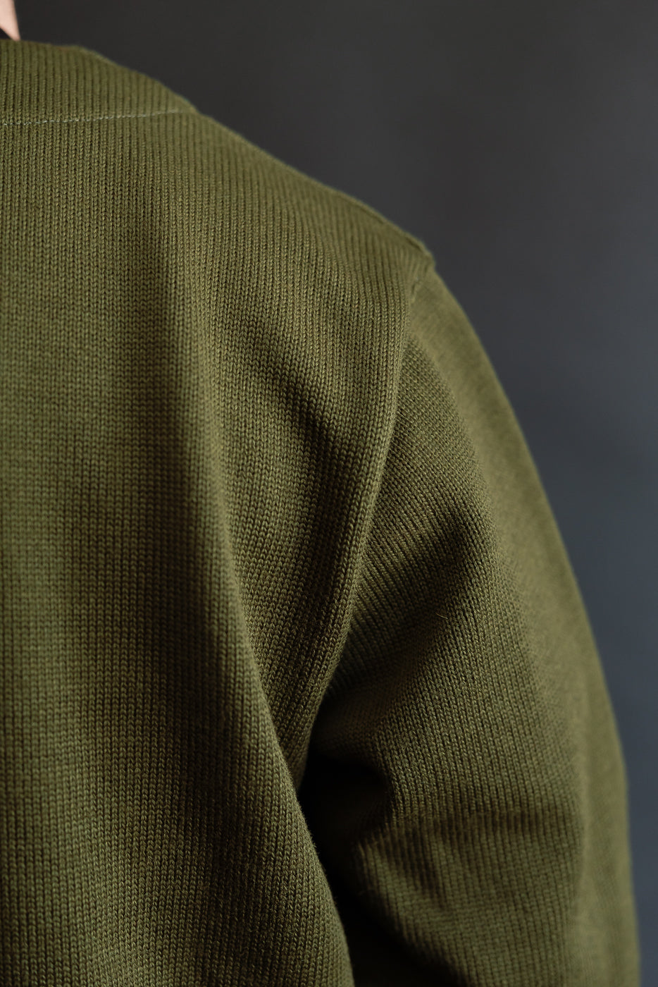shoulder seam of olive green cardigan