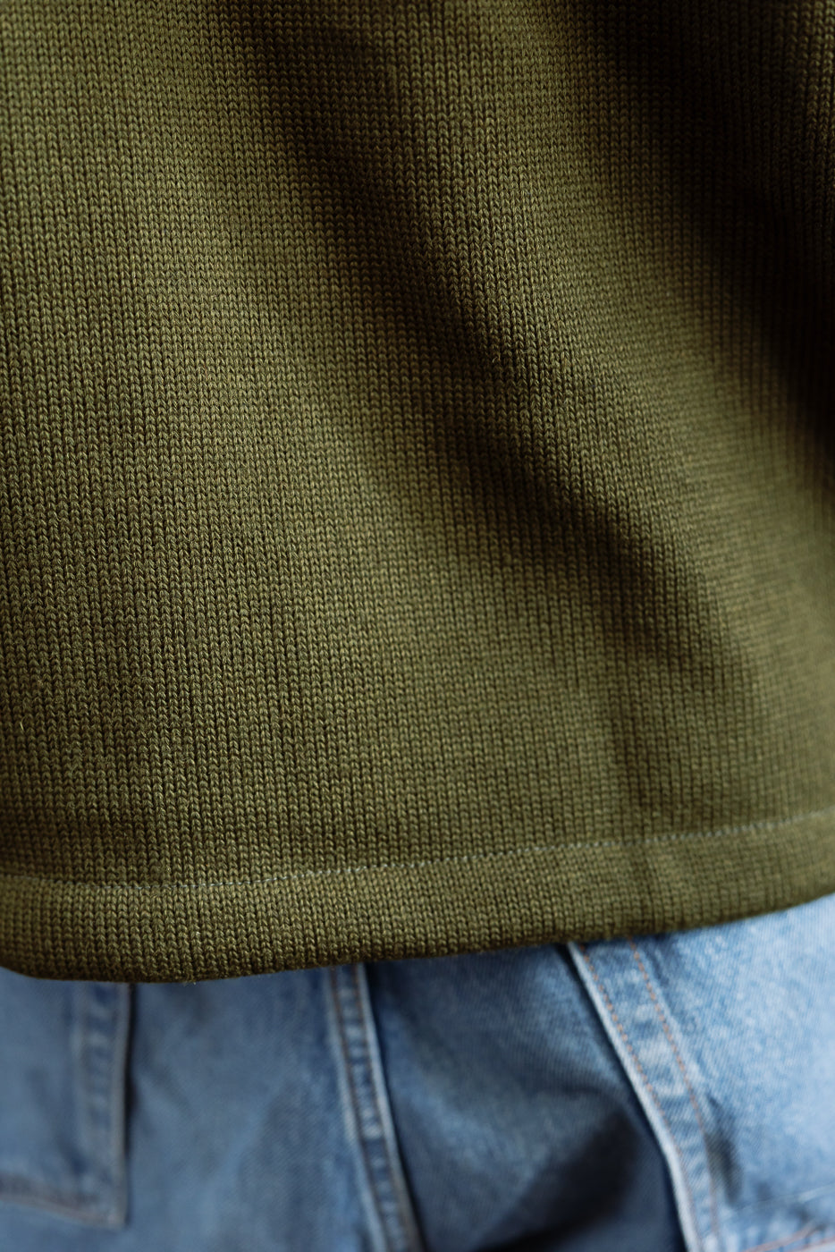 hem close up of olive green cardigan