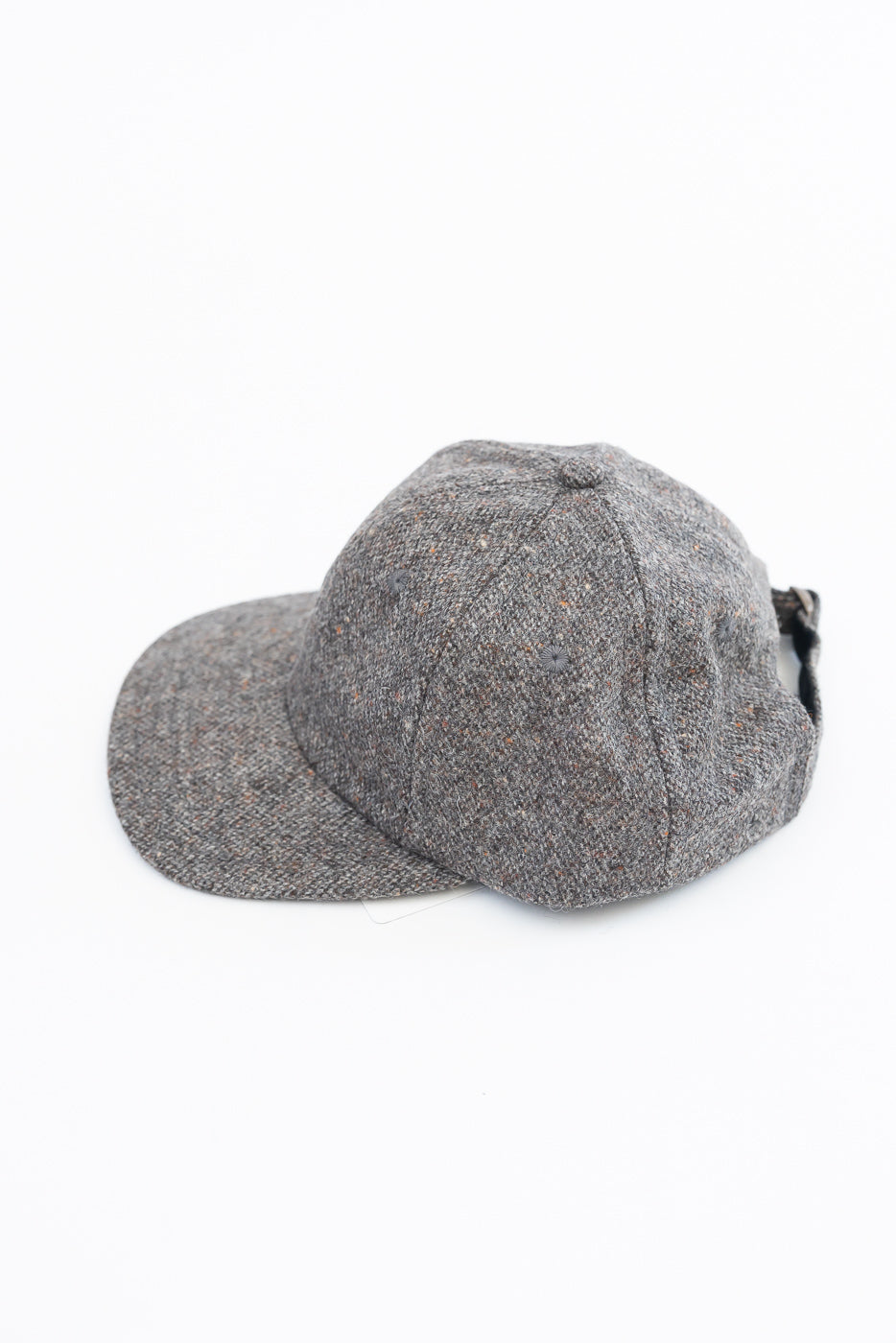 Close-up side view of a grey textured fabric baseball cap.