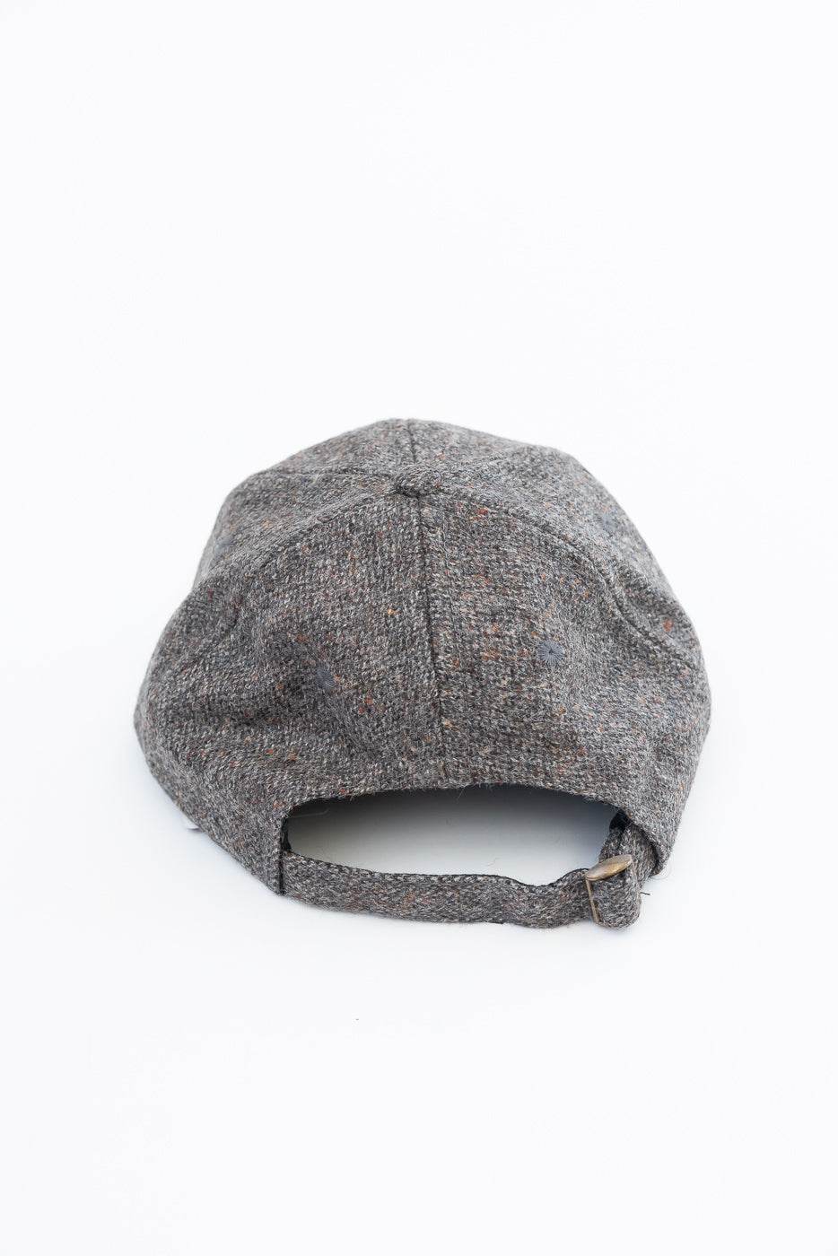 Back view close-up of a grey textured fabric baseball cap with an adjustable strap.