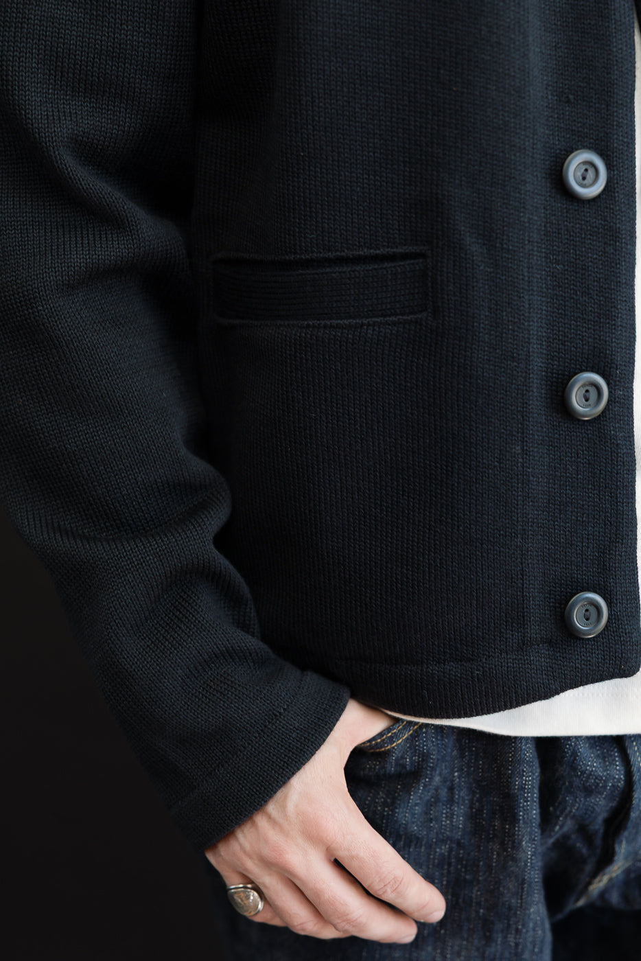 Side view close-up of a black textured knit jacket on a 5'9
