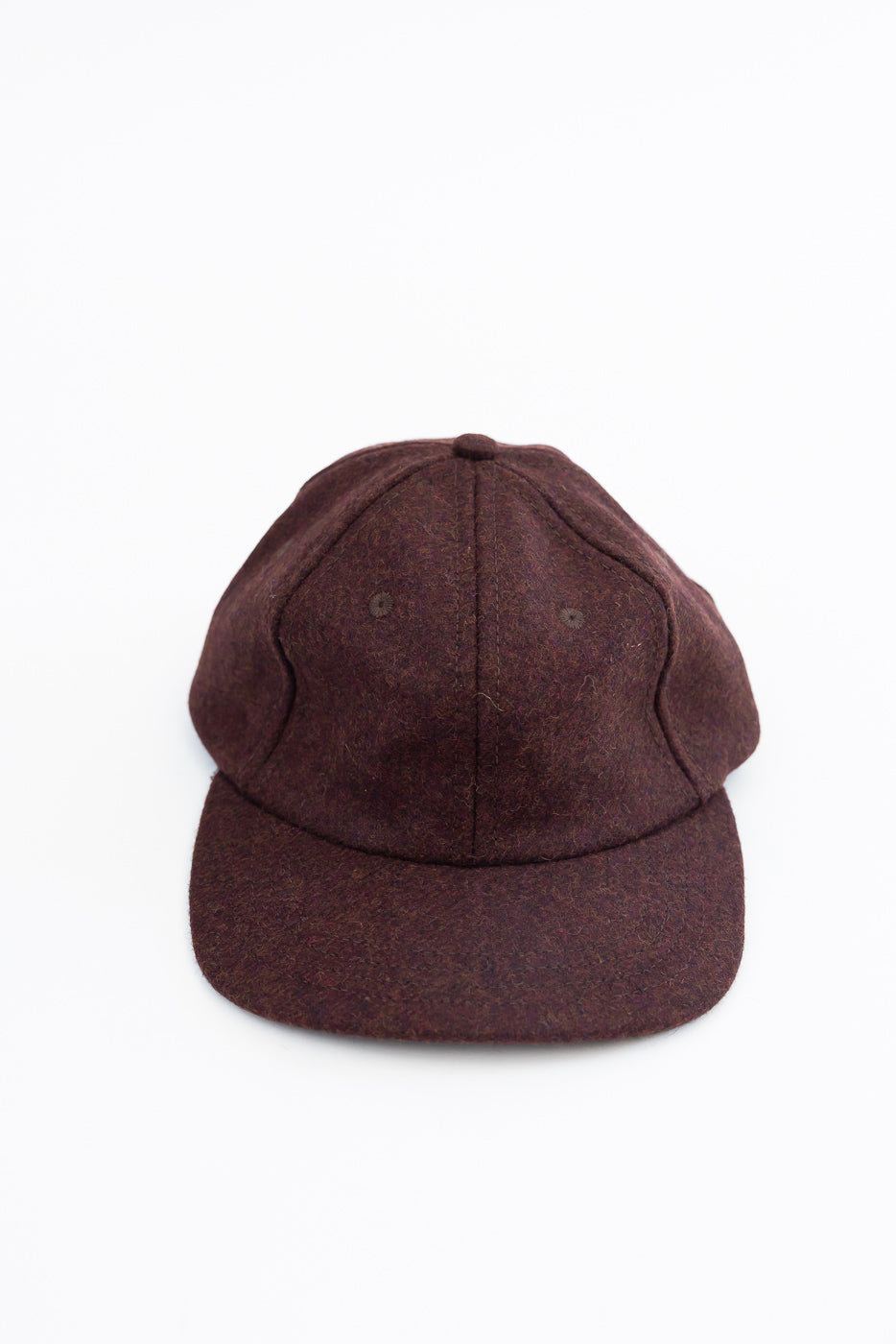 Front view close-up of a dark brown textured wool baseball cap on a white background.