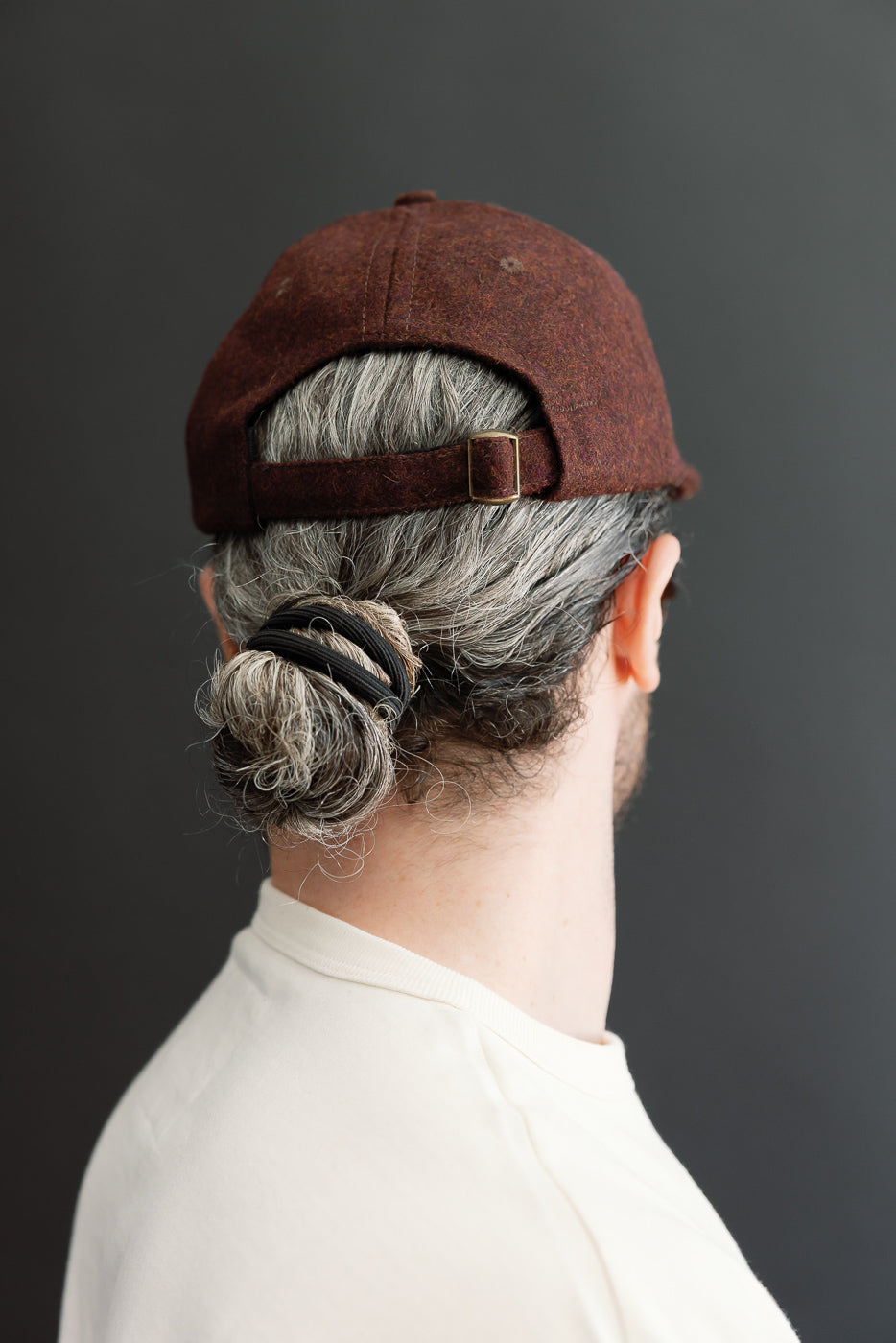 Close-up back view of a brown textured cap on a male model, 5'9