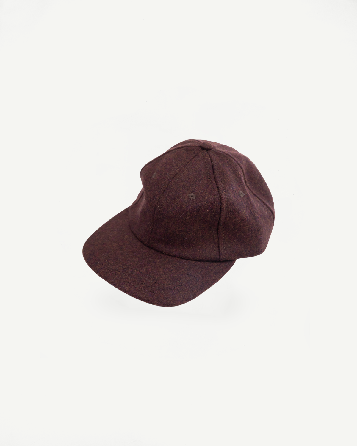 Close-up of the front and side of a dark brown wool baseball cap showing fabric texture.