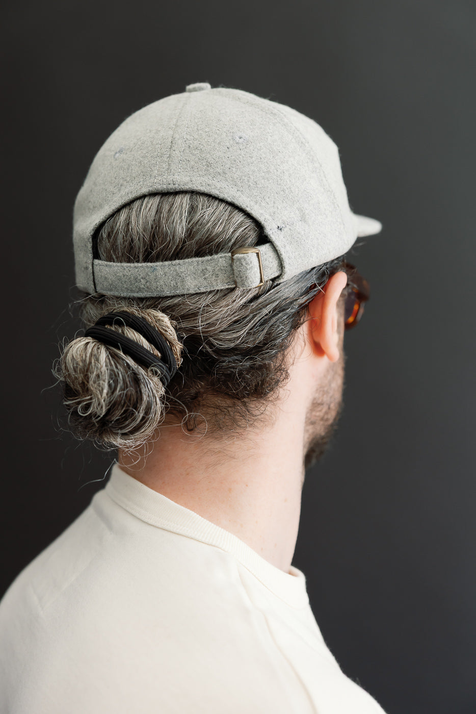 Close-up back view of a light gray wool baseball cap on a male model, 5'9