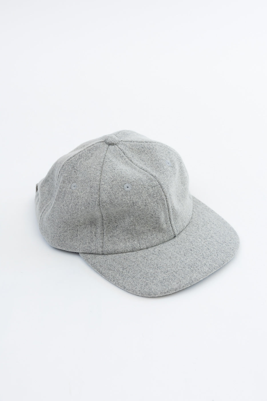 Close-up, front view of a grey felt baseball cap showing fabric texture.