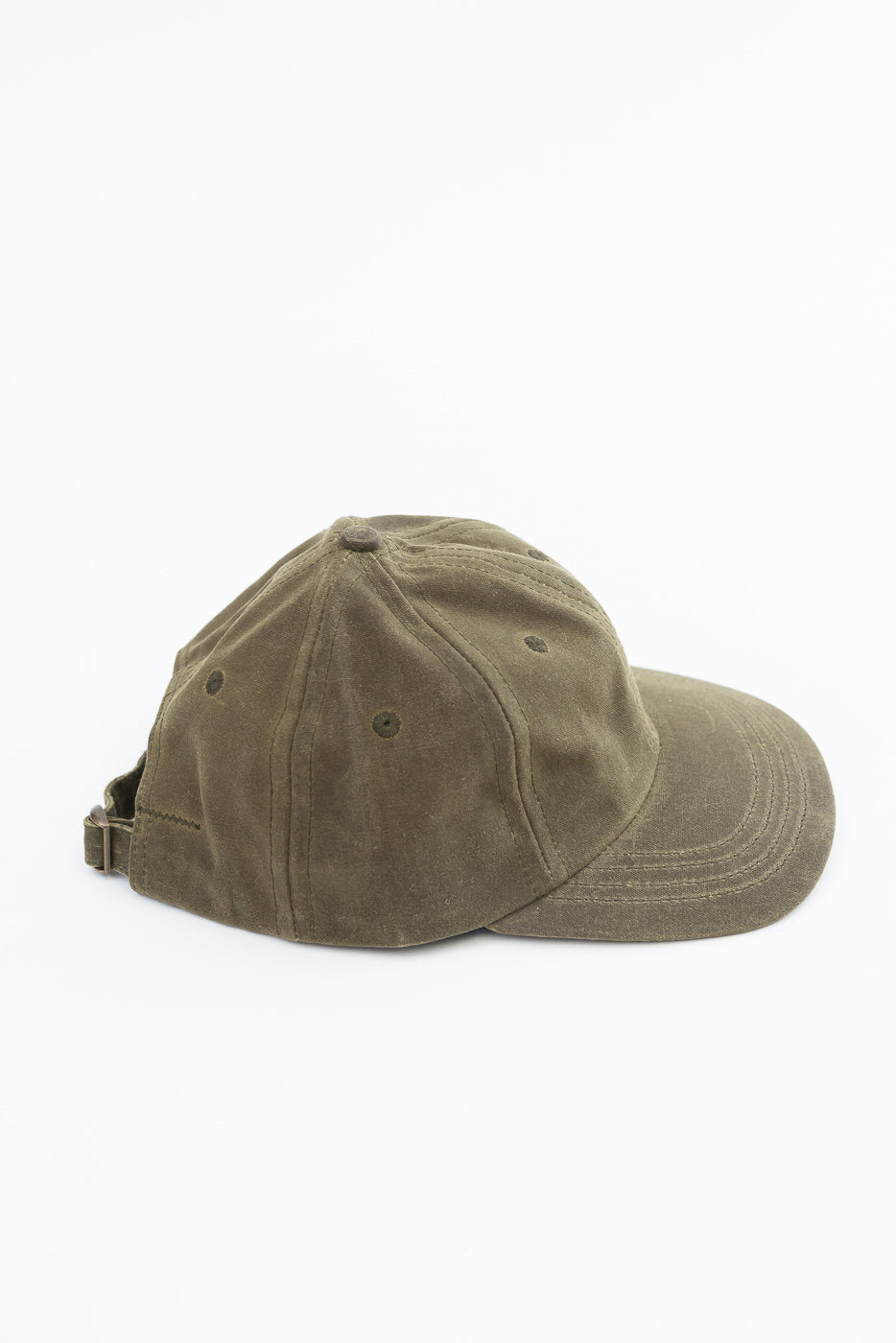 Close-up side view of an olive green twill baseball cap with an adjustable strap.