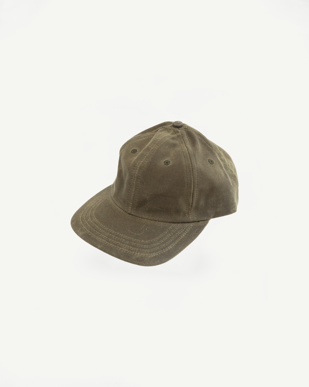 Three-quarter view of a washed olive green canvas baseball cap against a white background.