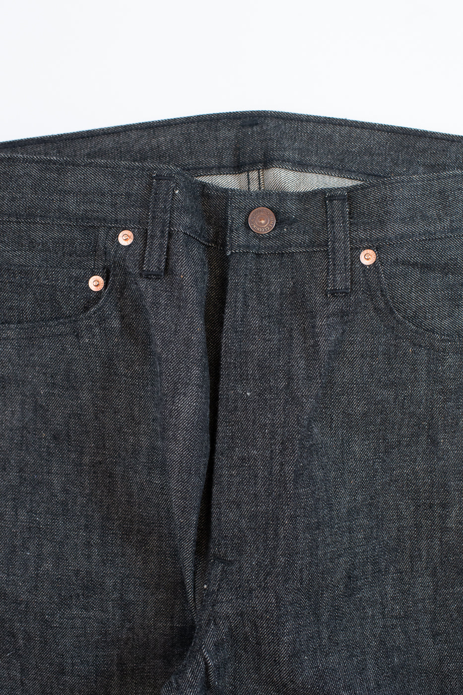 close up of key hole on black jeans on a white background