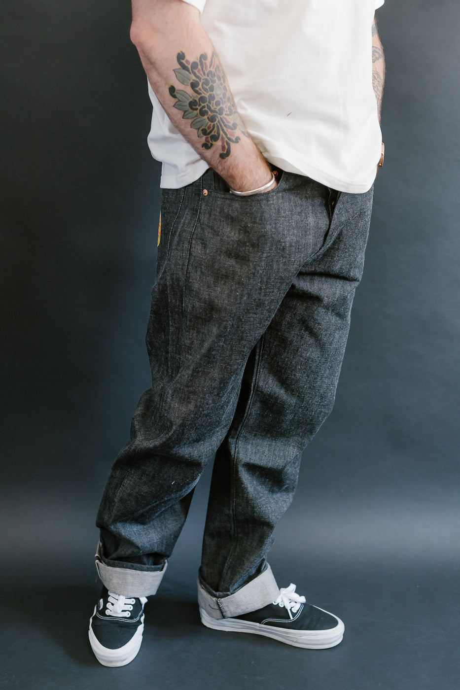 man wearing denime black mother cotton denim jeans 3/4 view, side
