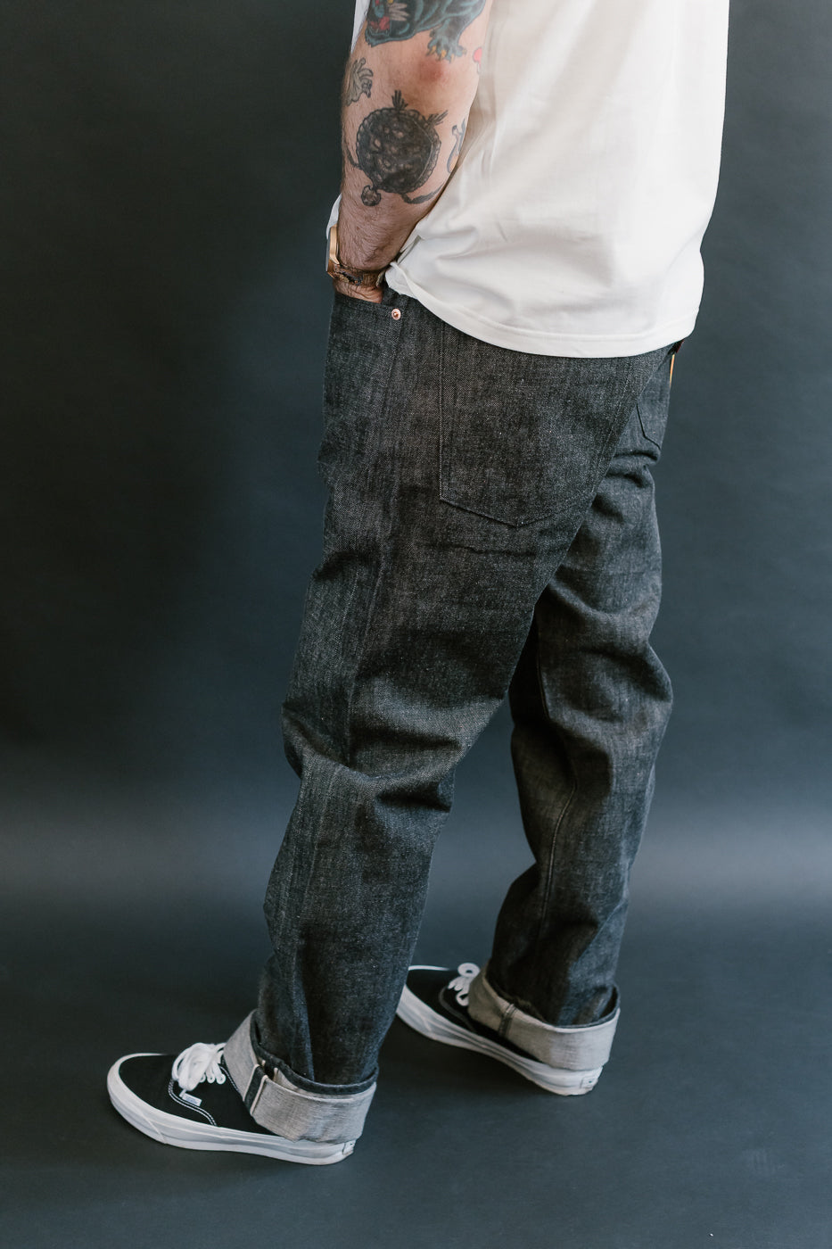 man wearing denime black mother cotton denim jeans 3/4 view, side
