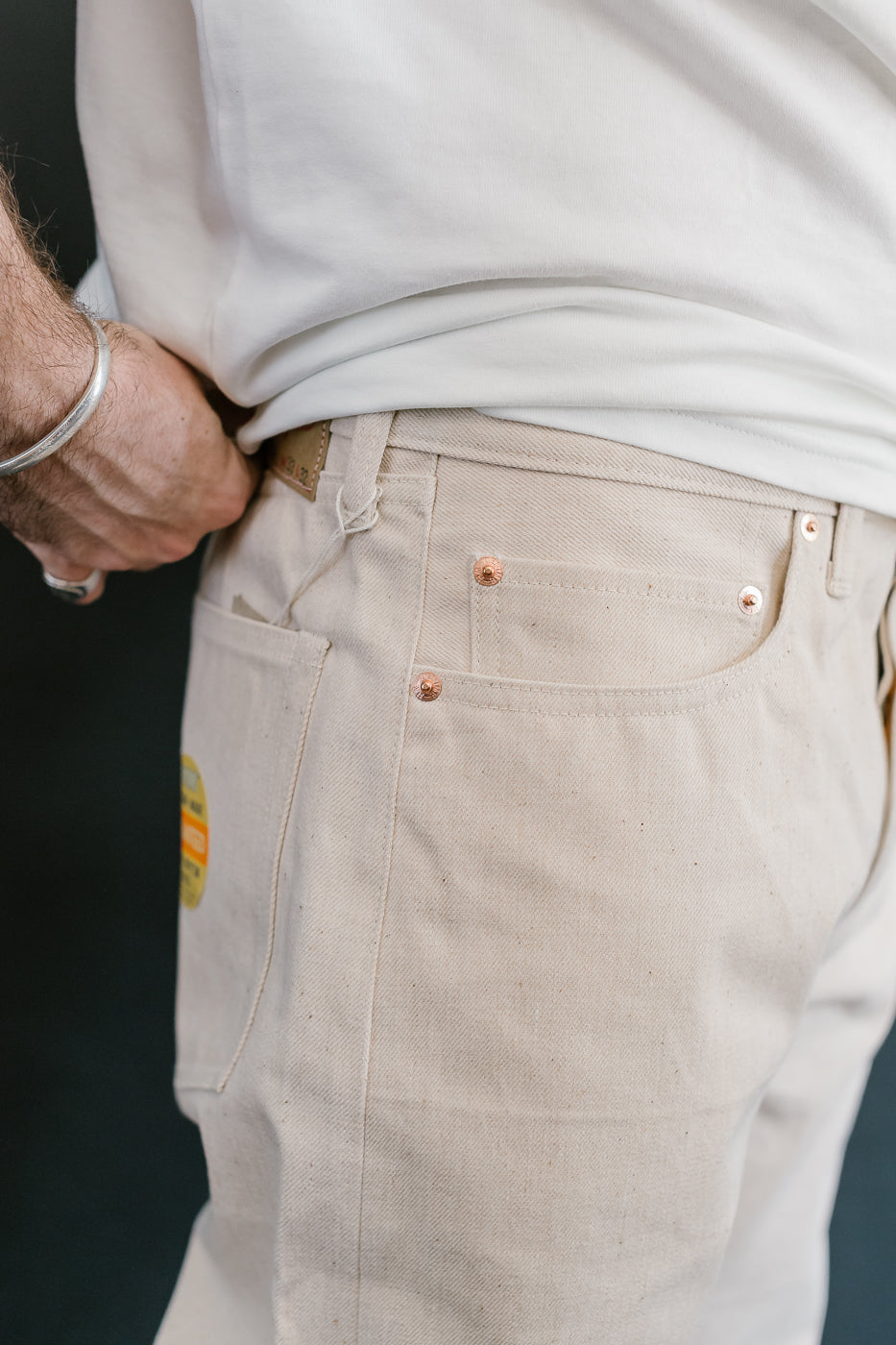 Close-up of beige pants with a dark background