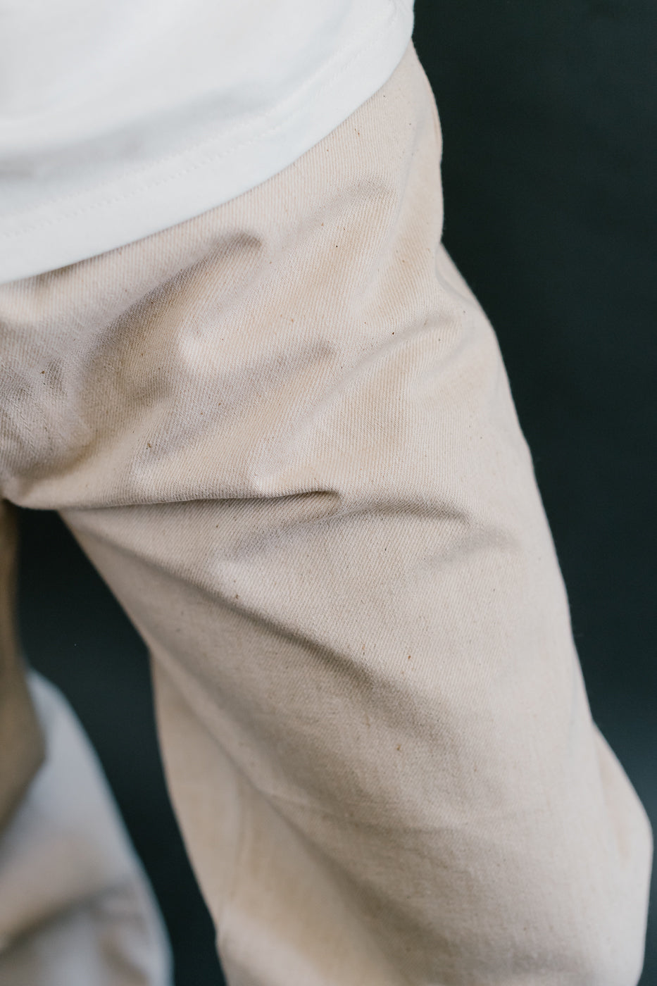 Close-up of beige pants with a dark background