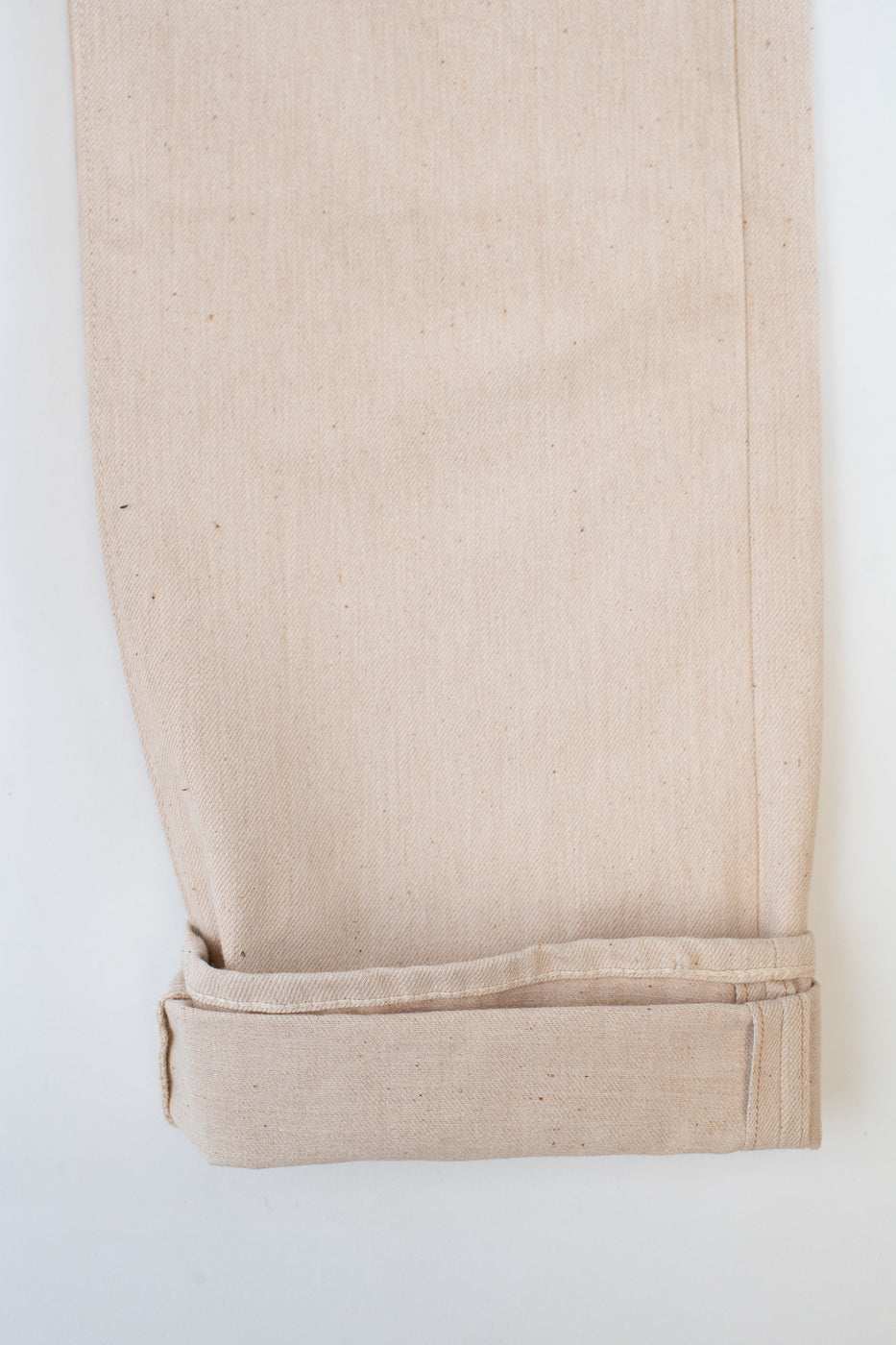 Close-up of beige pants with a white background
