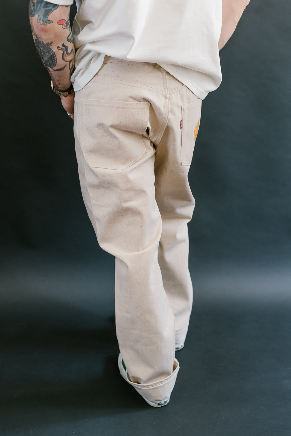 Person wearing beige cargo pants on a dark background