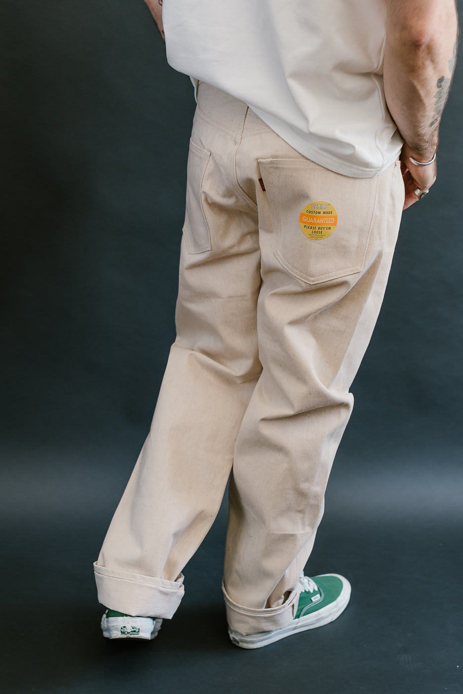Person wearing beige cargo pants with a visible brand logo on a dark background
