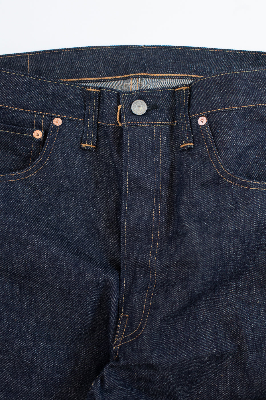 Close-up of dark blue denim jeans on a white background